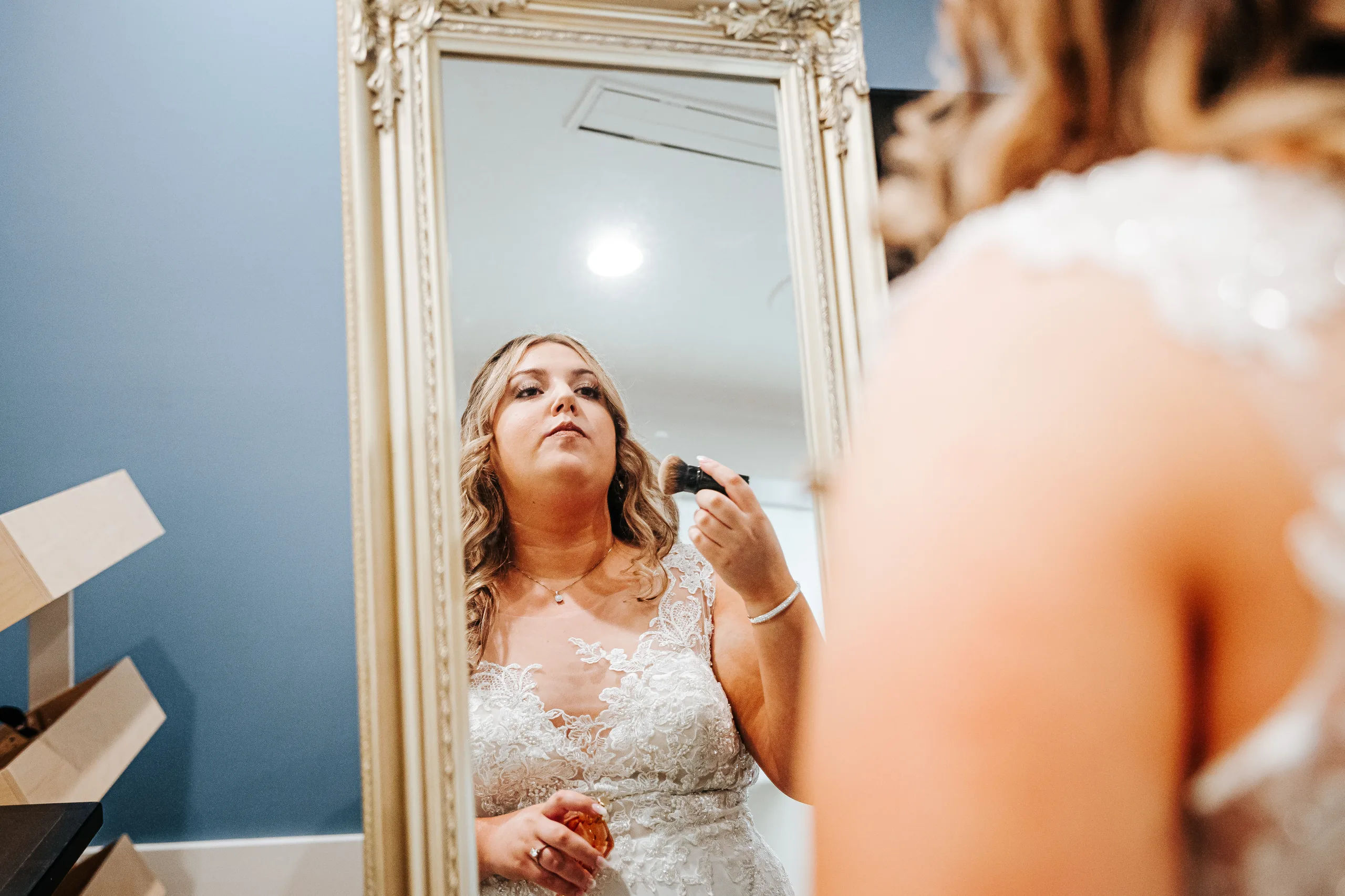 Getting Ready: the bride finishing her makeup in the mirror before their wedding at the Country Club of Roswell in Roswell, GA