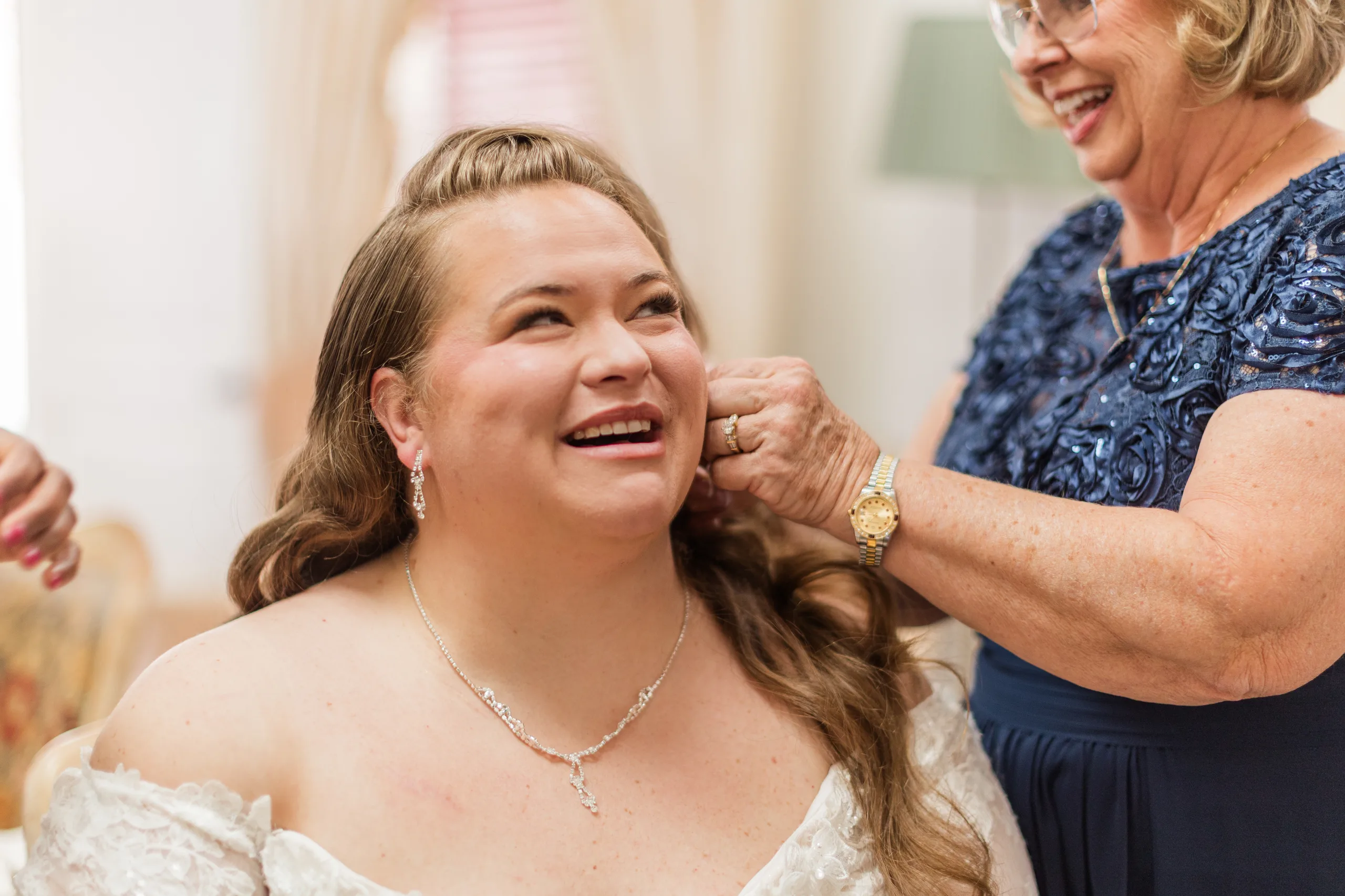 Getting Ready: her mom helping with her earrings, before their wedding at 550 Trackside in Lawrenceville, GA