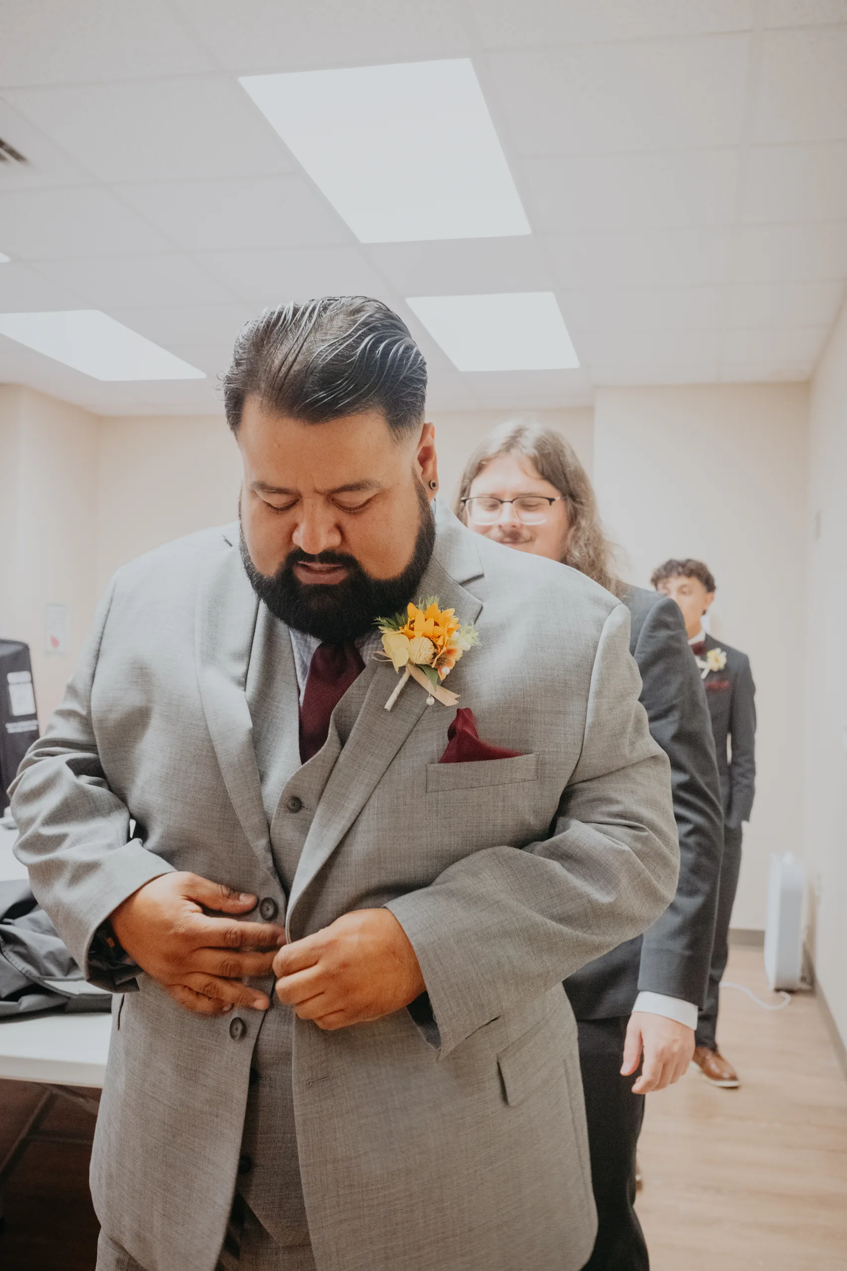 Getting Ready: the groom buttoning his jacket, before their wedding at St. Lawrence Catholic Church in Lawrenceville, GA