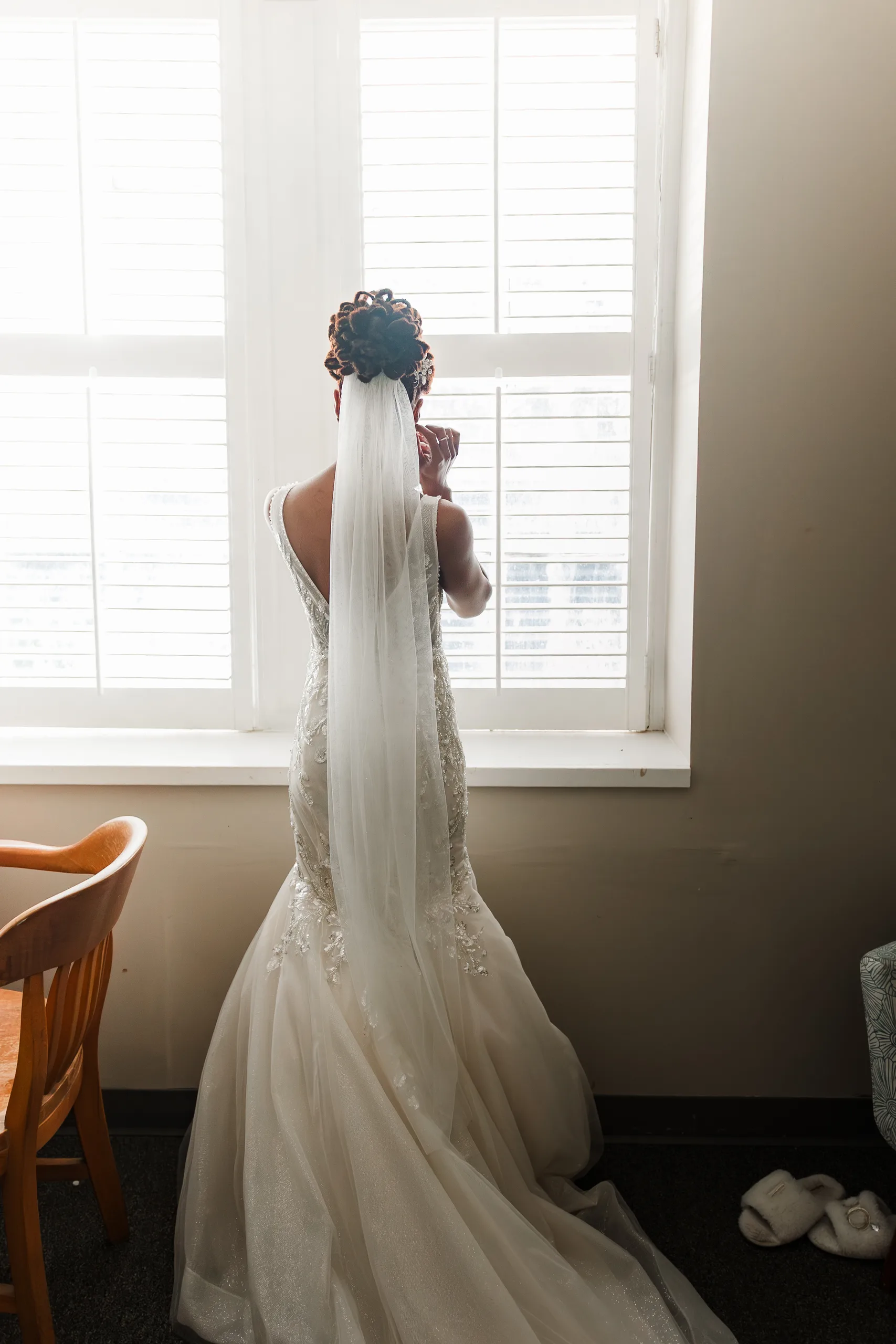 Getting Ready: the bride at the window in her veil, before their wedding at the Historic DeKalb Courthouse in Decatur, GA