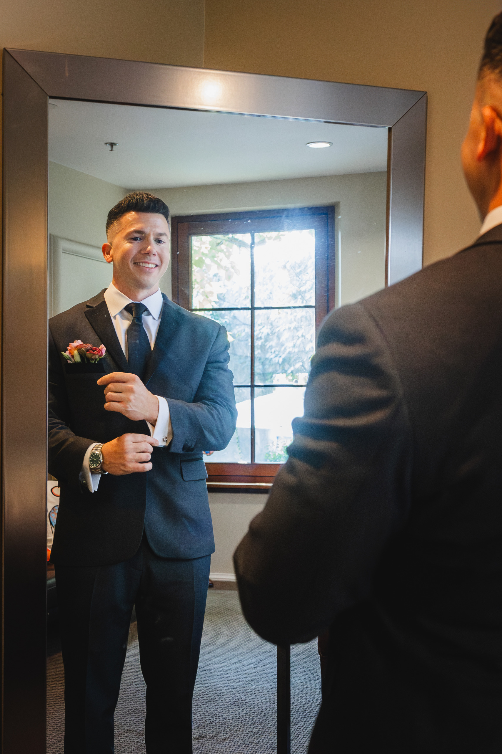 Getting Ready: the groom fixing his cuff in the mirror, before their wedding at Summerour Studio in Atlanta, GA