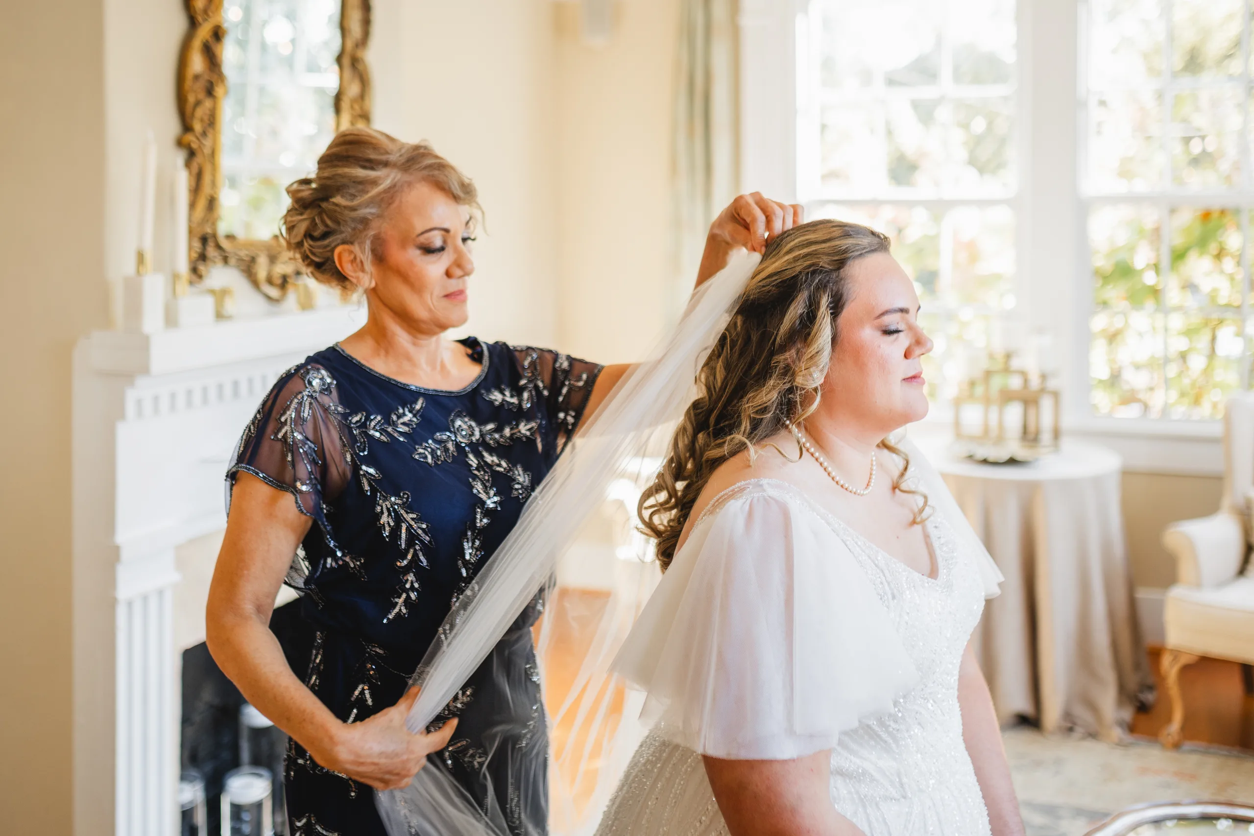 Getting Ready: her veil going in by the big windows, before their wedding at Naylor Hall in Roswell, GA