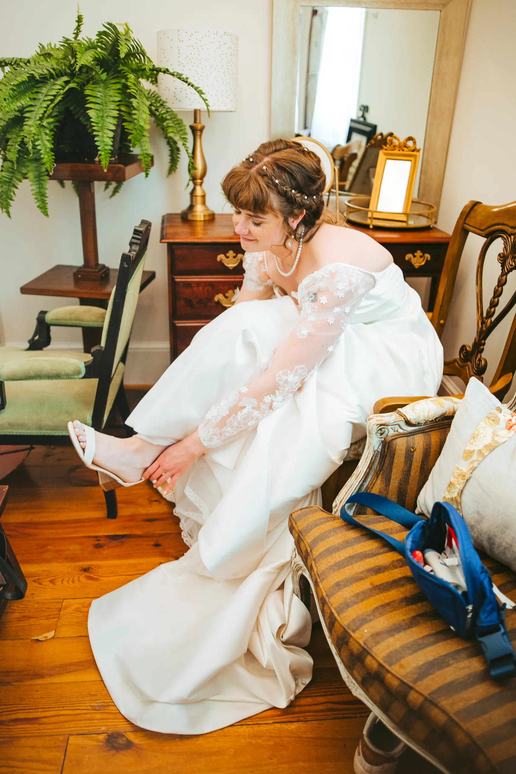 Getting Ready: the bride putting on her shoes, before their wedding at the Chapel at Simpsonwood Park in Peachtree Corners, GA