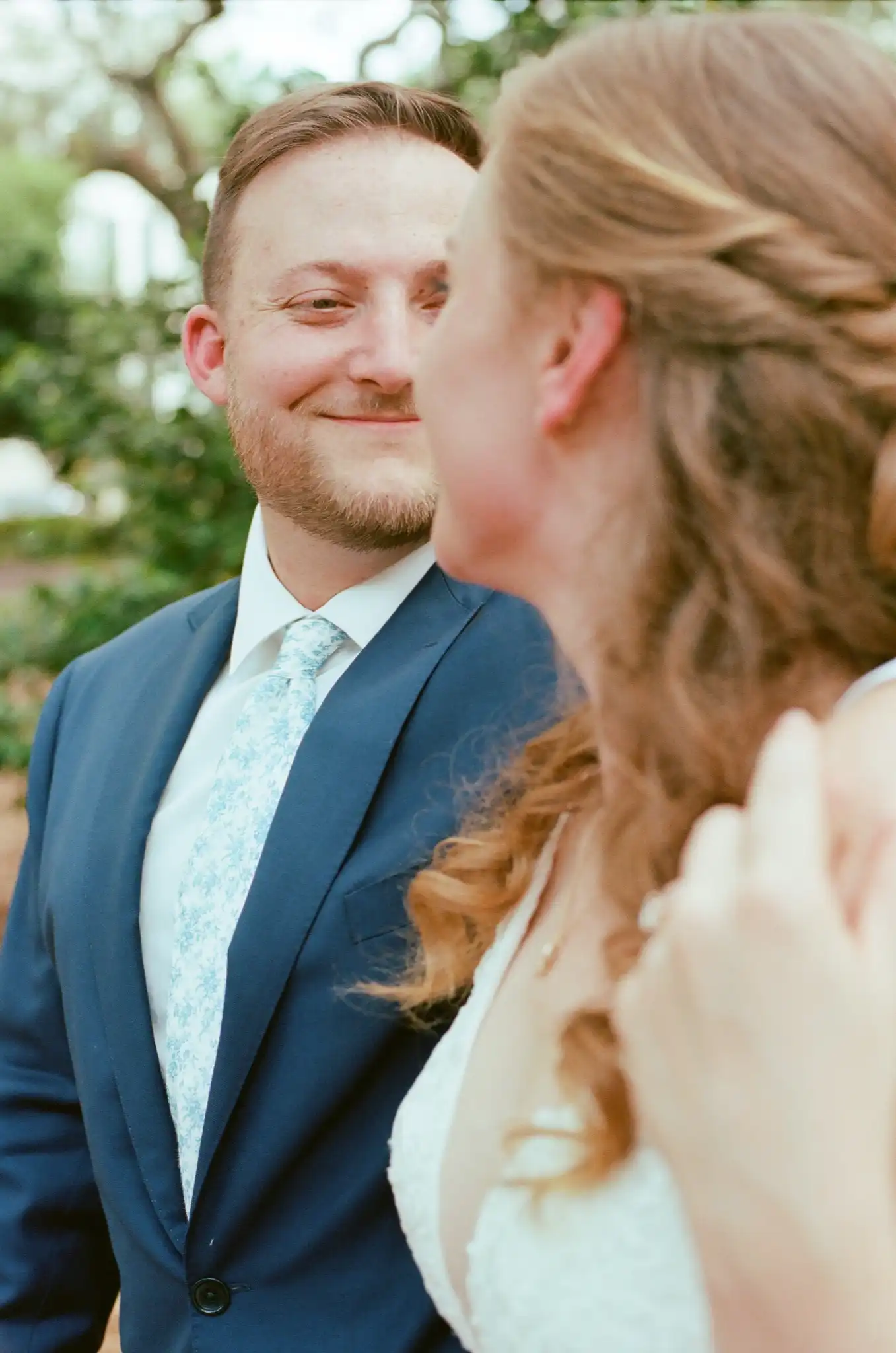 Groom smiling at his bride during their portraits, shot on 35mm film in Savannah, Georgia