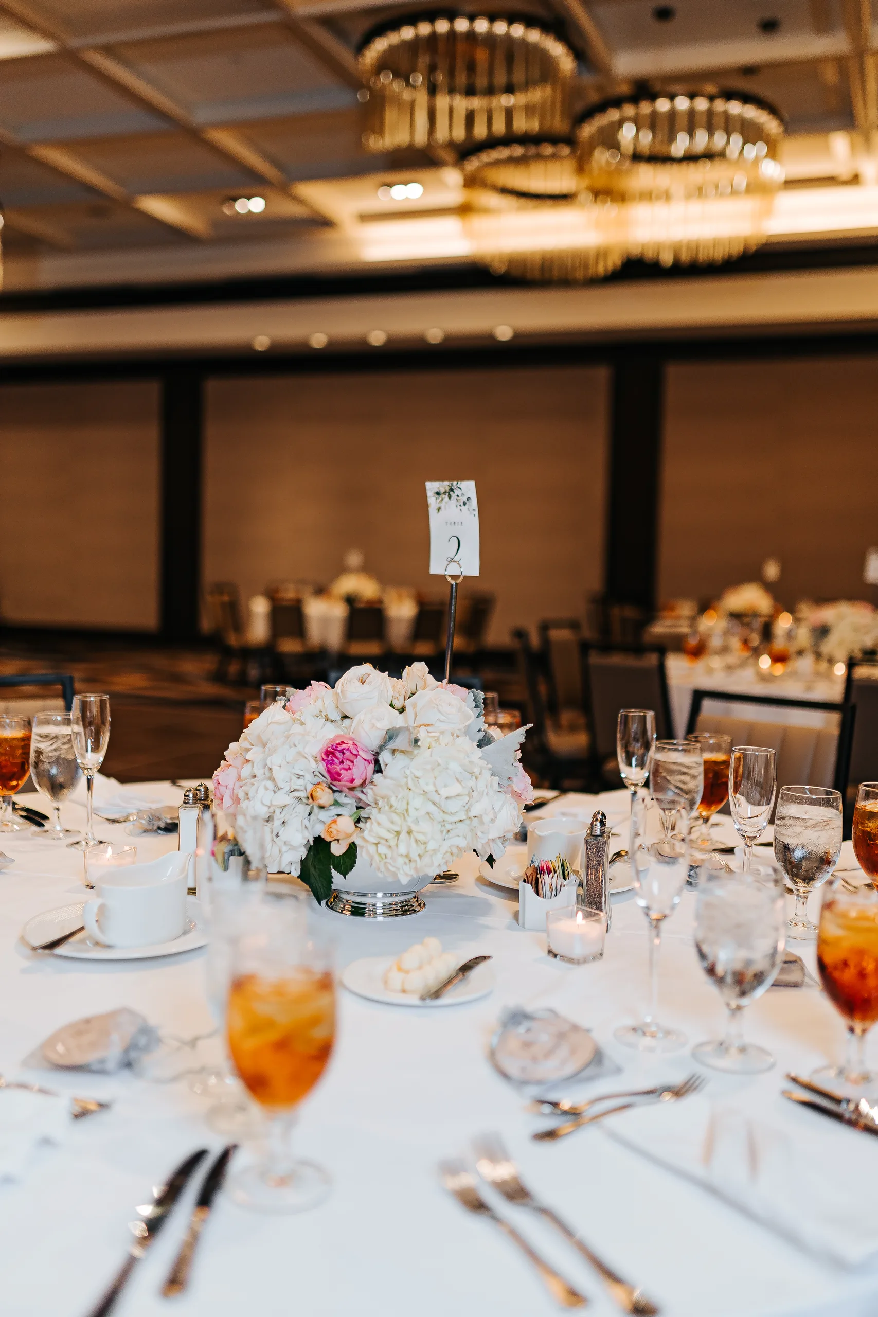 Reception Details: a table centerpiece in the ballroom at a wedding at the Omni Hotel at The Battery in Atlanta, GA