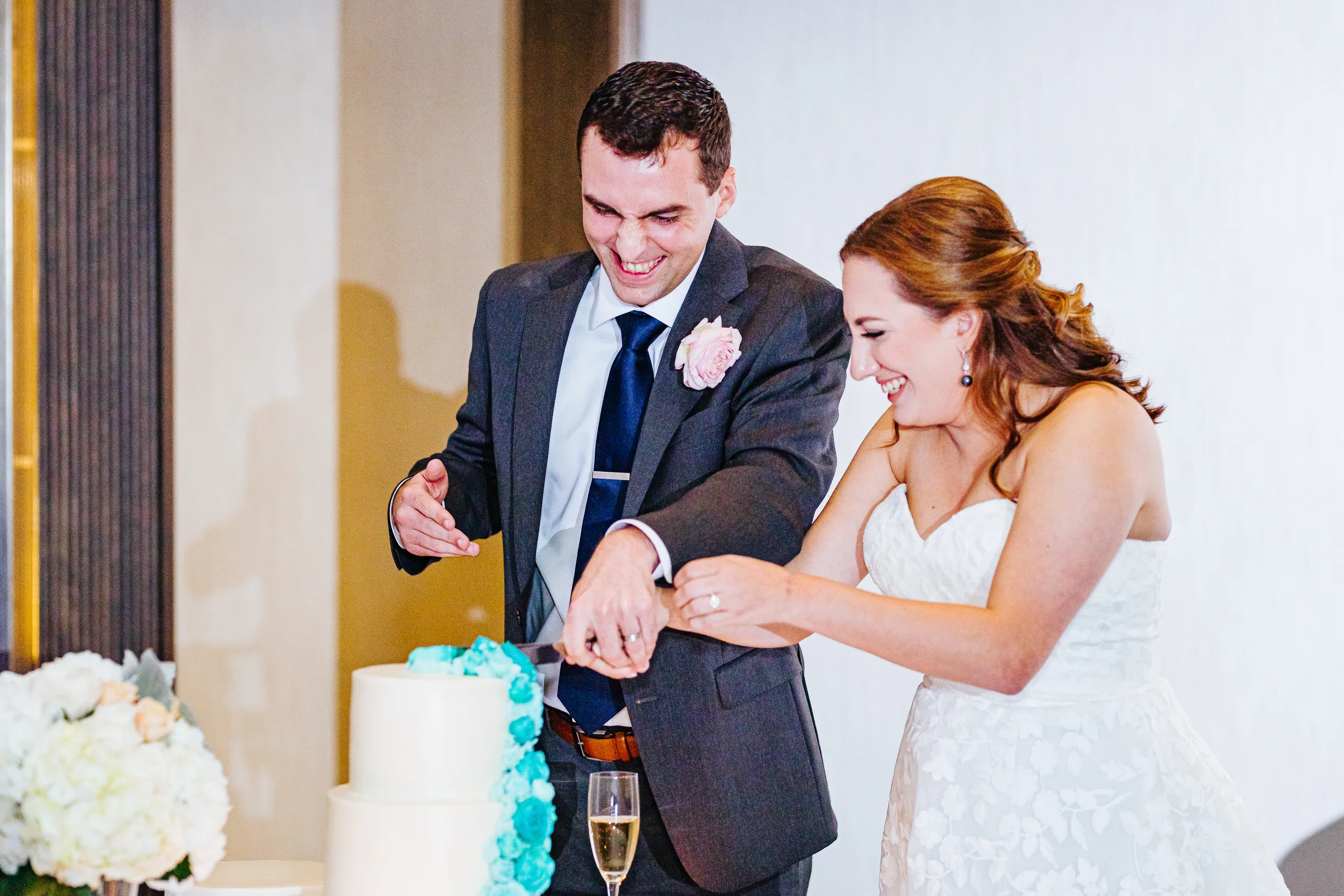 Reception: laughing as they cut the cake at their wedding at the Omni Hotel at The Battery in Atlanta, GA
