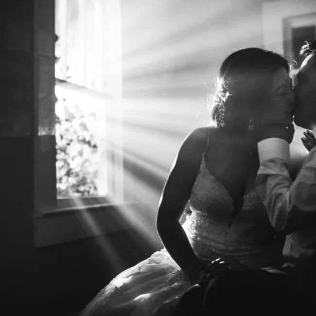 Night Portraits: a kiss by the window, in black and white at their wedding at the Payne-Corley House in Duluth, GA