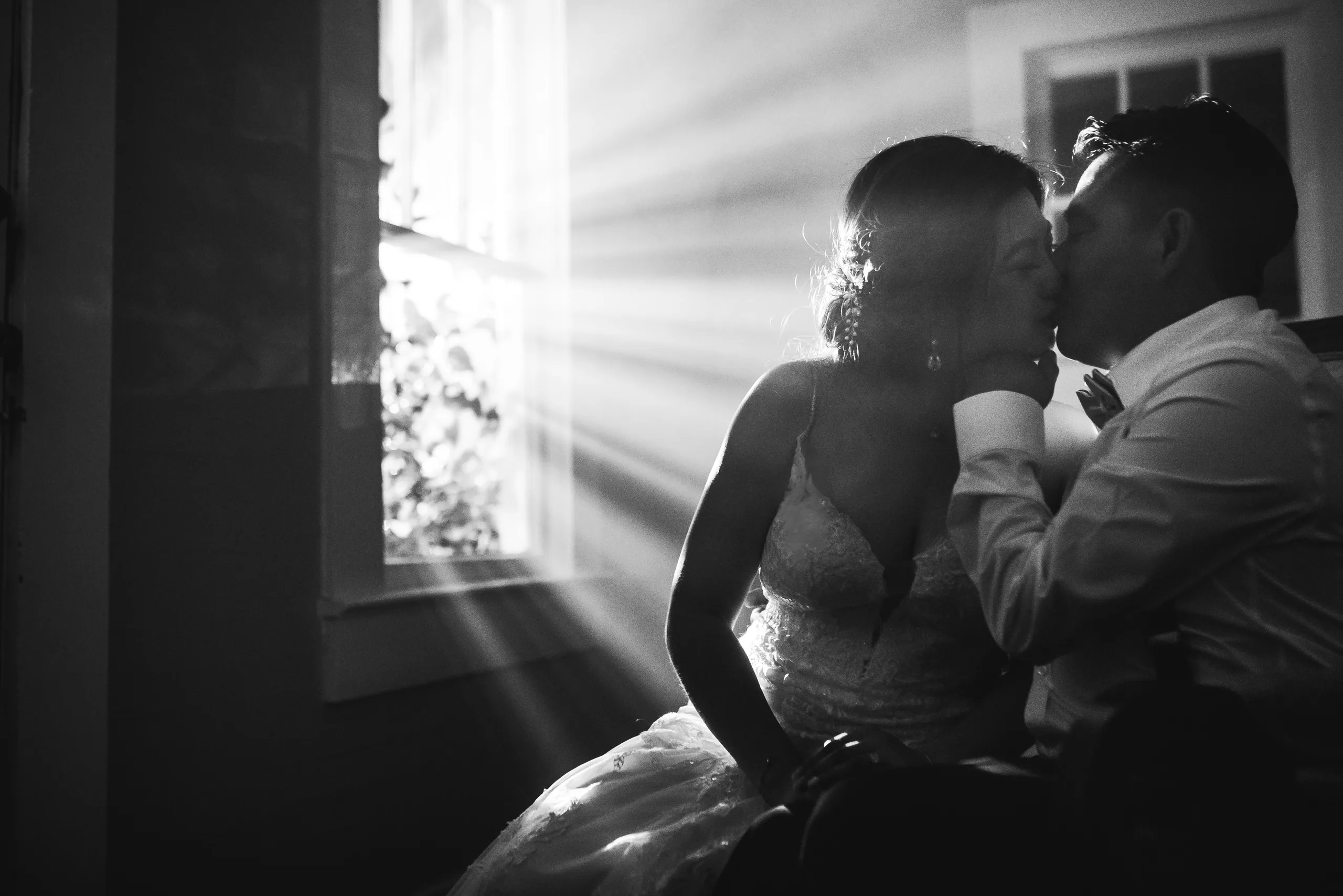 Night Portraits: a kiss by the window, in black and white at their wedding at the Payne-Corley House in Duluth, GA