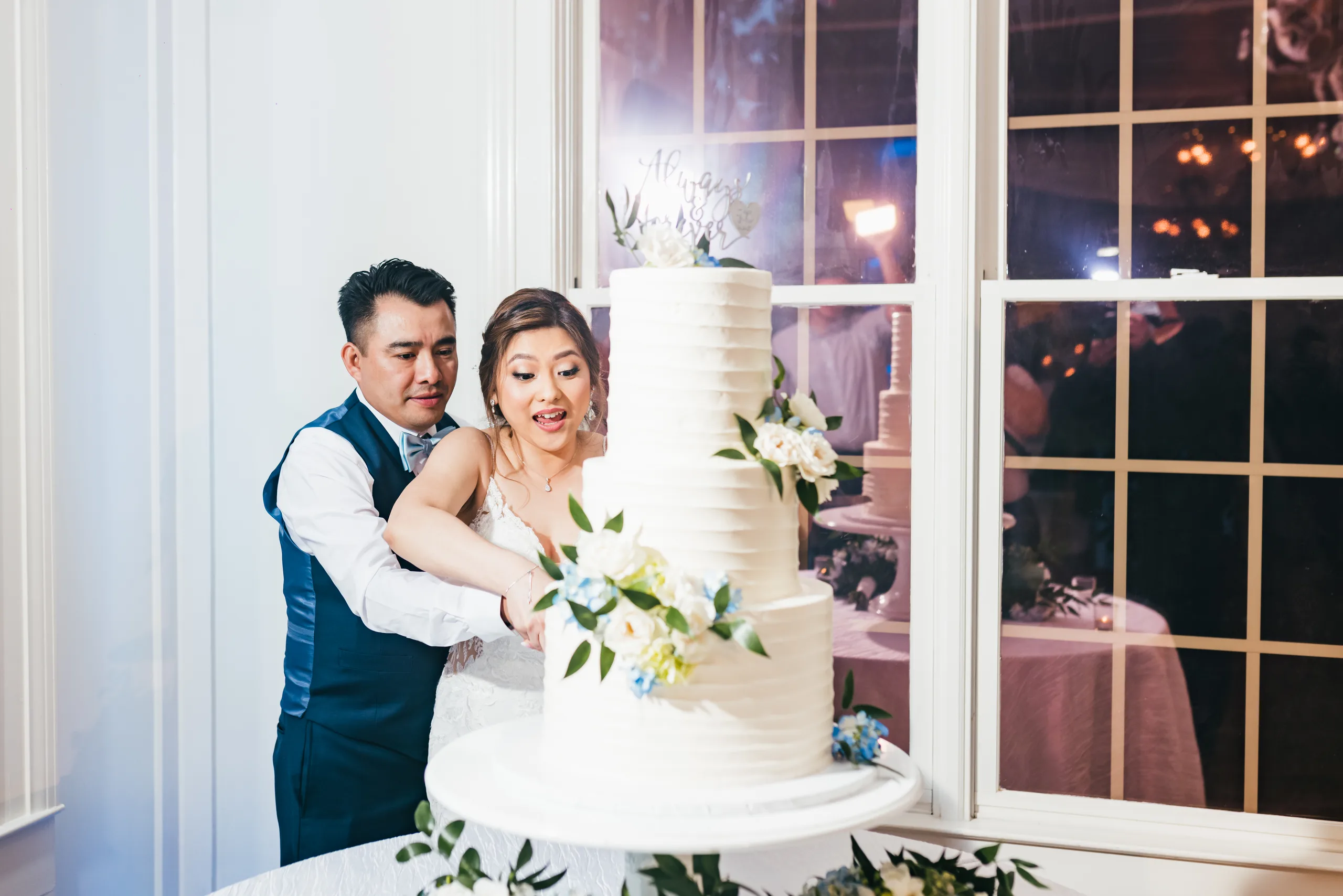Reception: cutting the cake by the window at their wedding at the Payne-Corley House in Duluth, GA