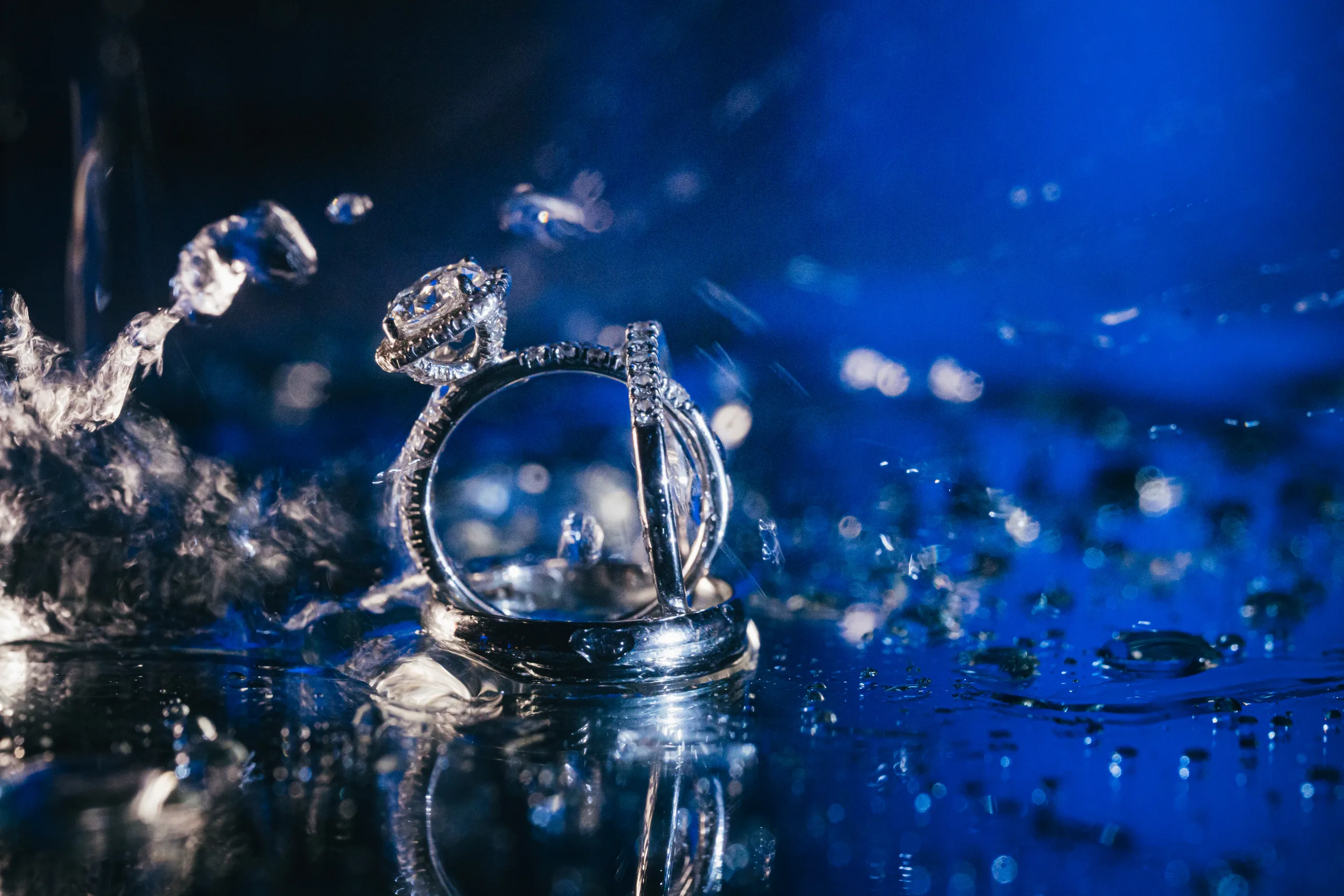 Wedding Details: her engagement ring and band in blue light at a wedding at the Payne-Corley House in Duluth, GA