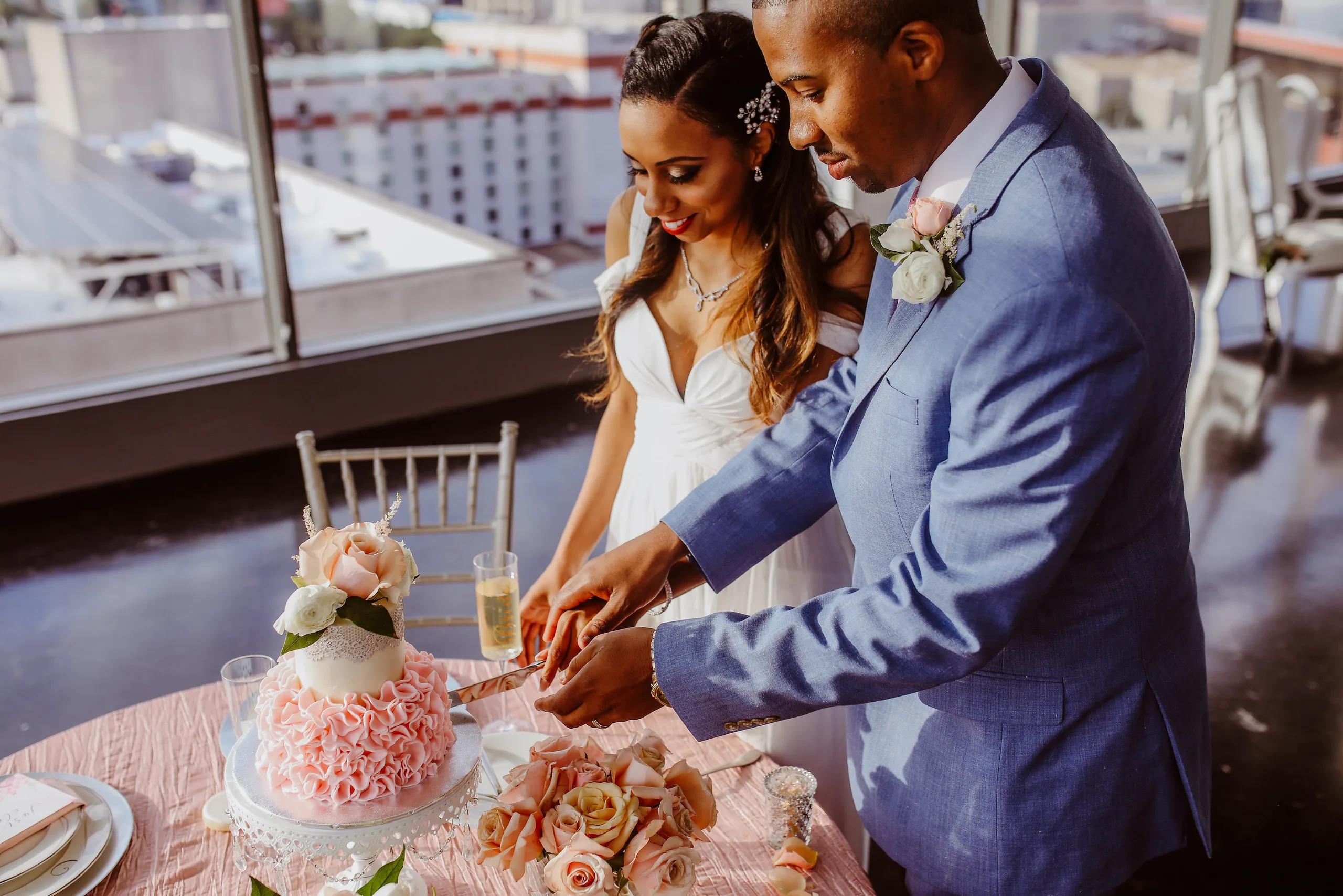 Cake Cutting: cutting the blush ruffled cake, seen from above, at their elopement at Ventanas in Atlanta, GA