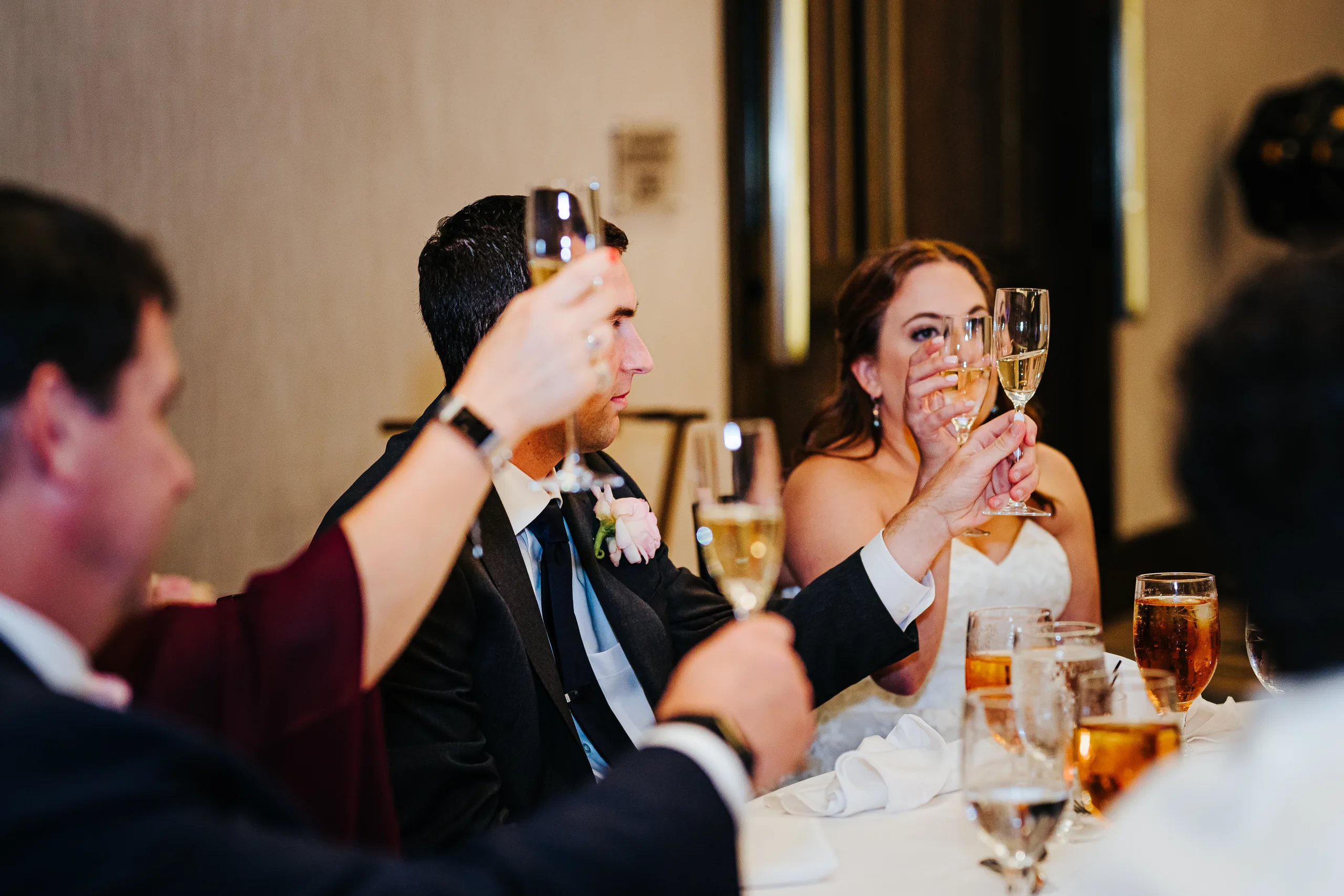 Reception: raising their glasses during the toasts at their wedding at the Omni Hotel at The Battery in Atlanta, GA