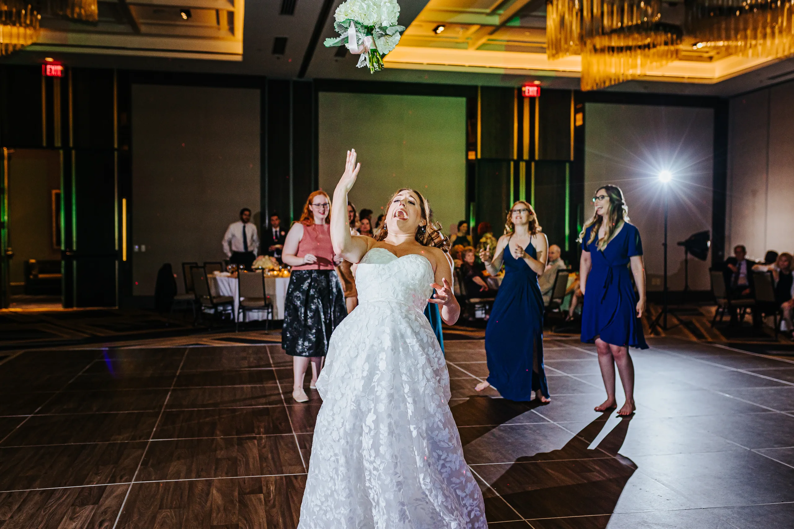 Reception: the bride tossing her bouquet at their wedding at the Omni Hotel at The Battery in Atlanta, GA