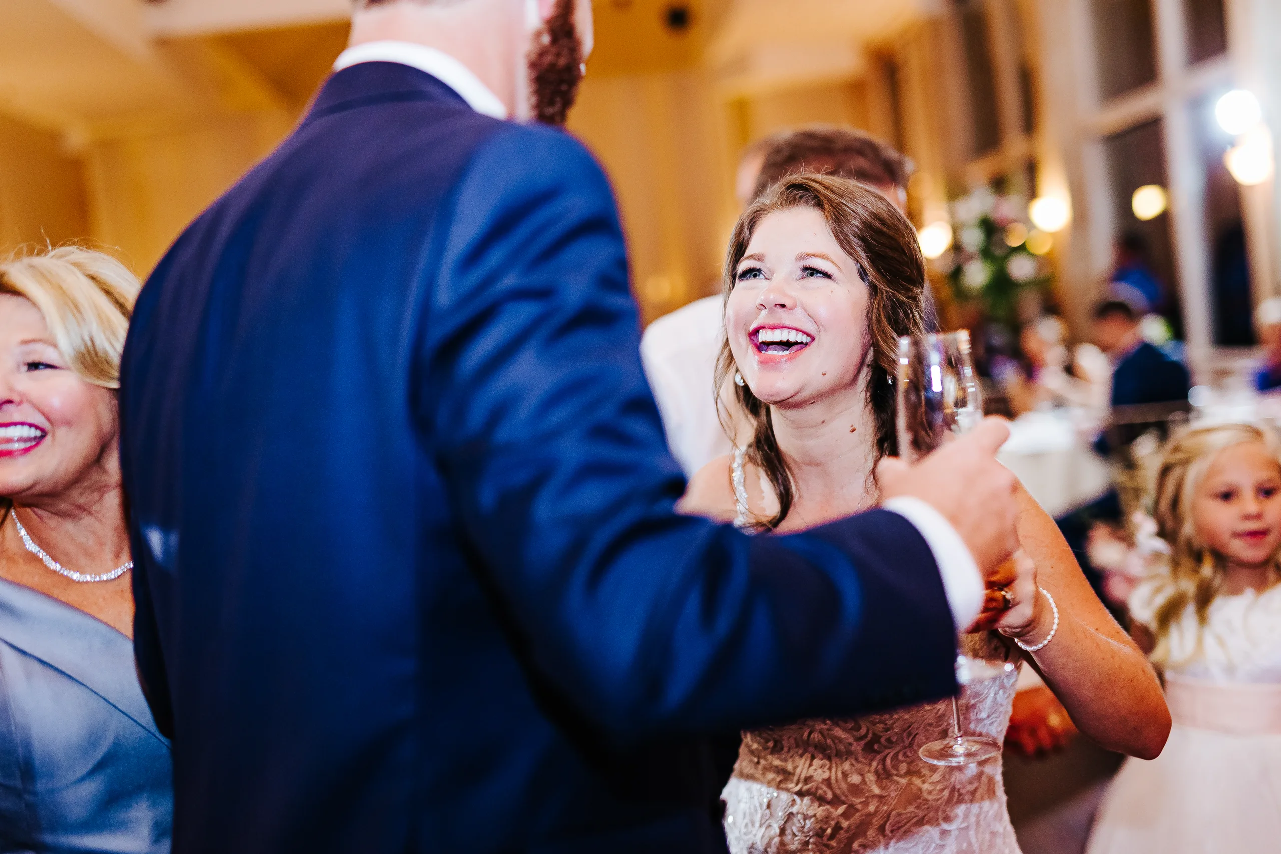Reception: the bride laughing with a glass of champagne, at their wedding at The Piedmont Room in Atlanta, GA