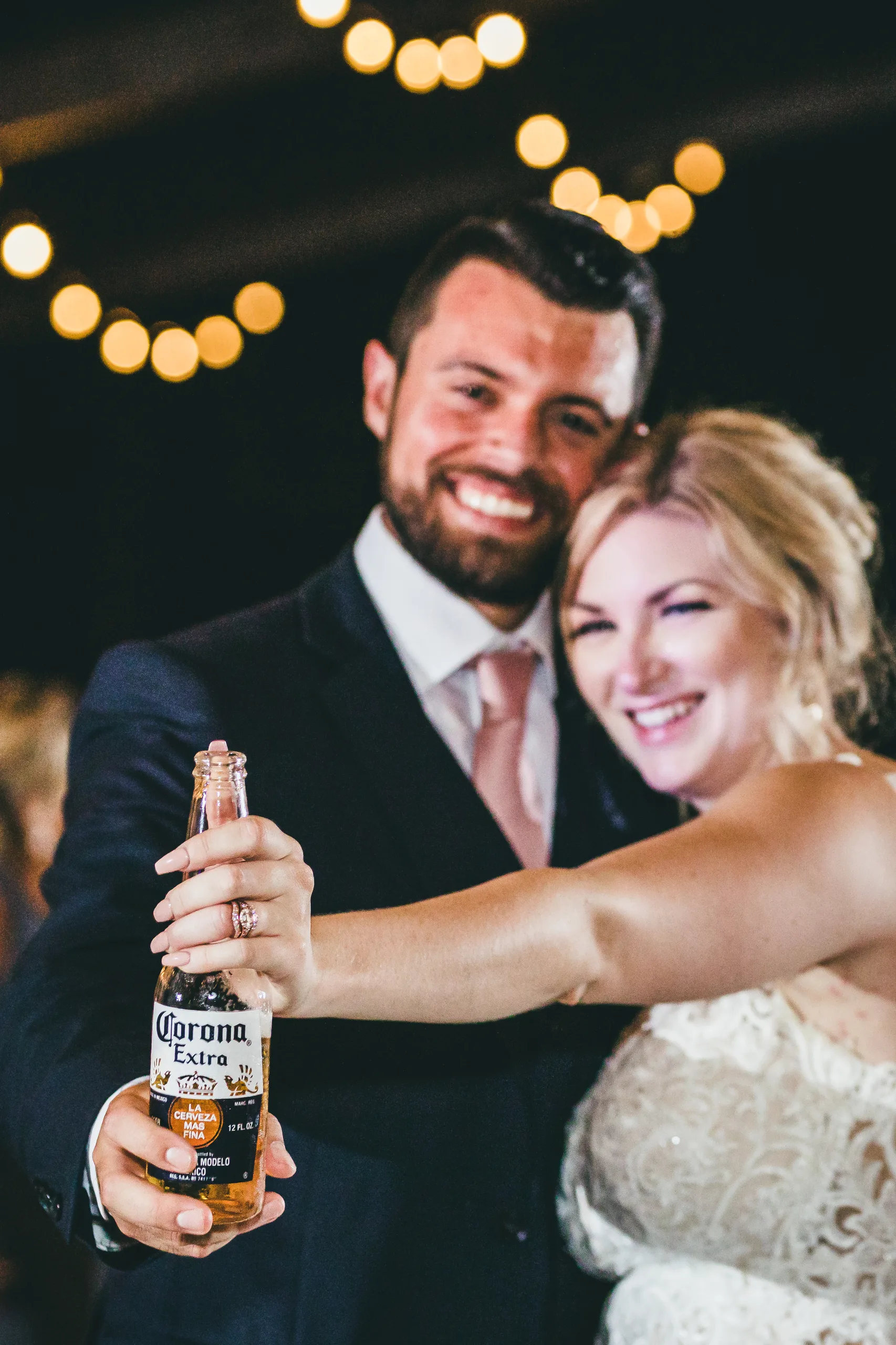 Reception: cheers with a Corona, her ring on show, at their wedding at Atlanta Evergreen Lakeside Resort in Stone Mountain, GA