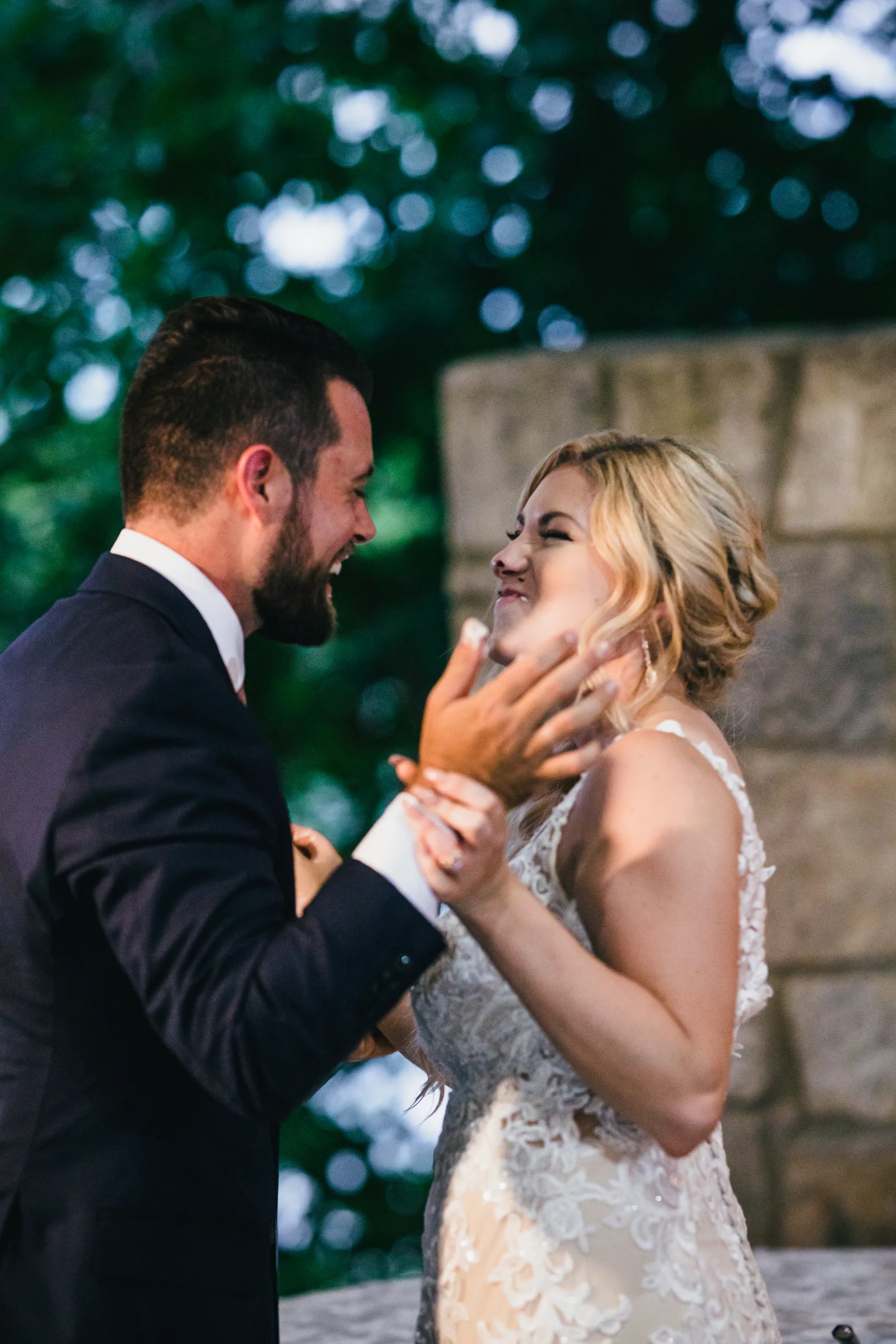 Reception: laughing with cake on her face, at their wedding at Atlanta Evergreen Lakeside Resort in Stone Mountain, GA