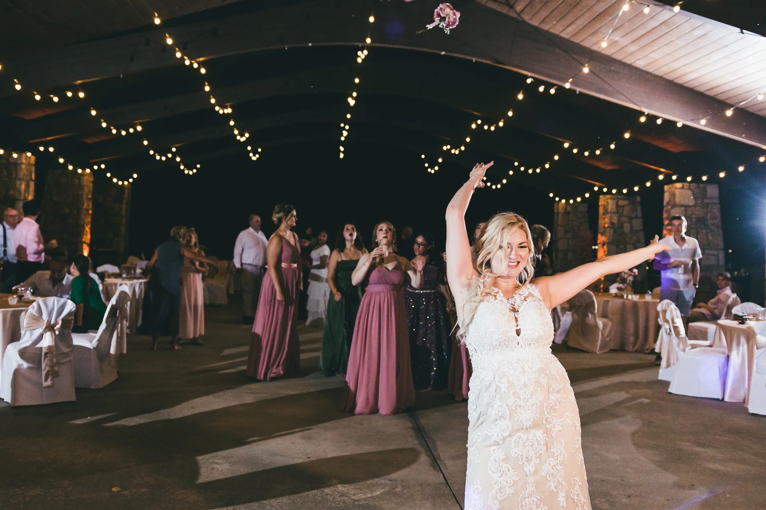 Reception: the bride tossing her bouquet, at their wedding at Atlanta Evergreen Lakeside Resort in Stone Mountain, GA