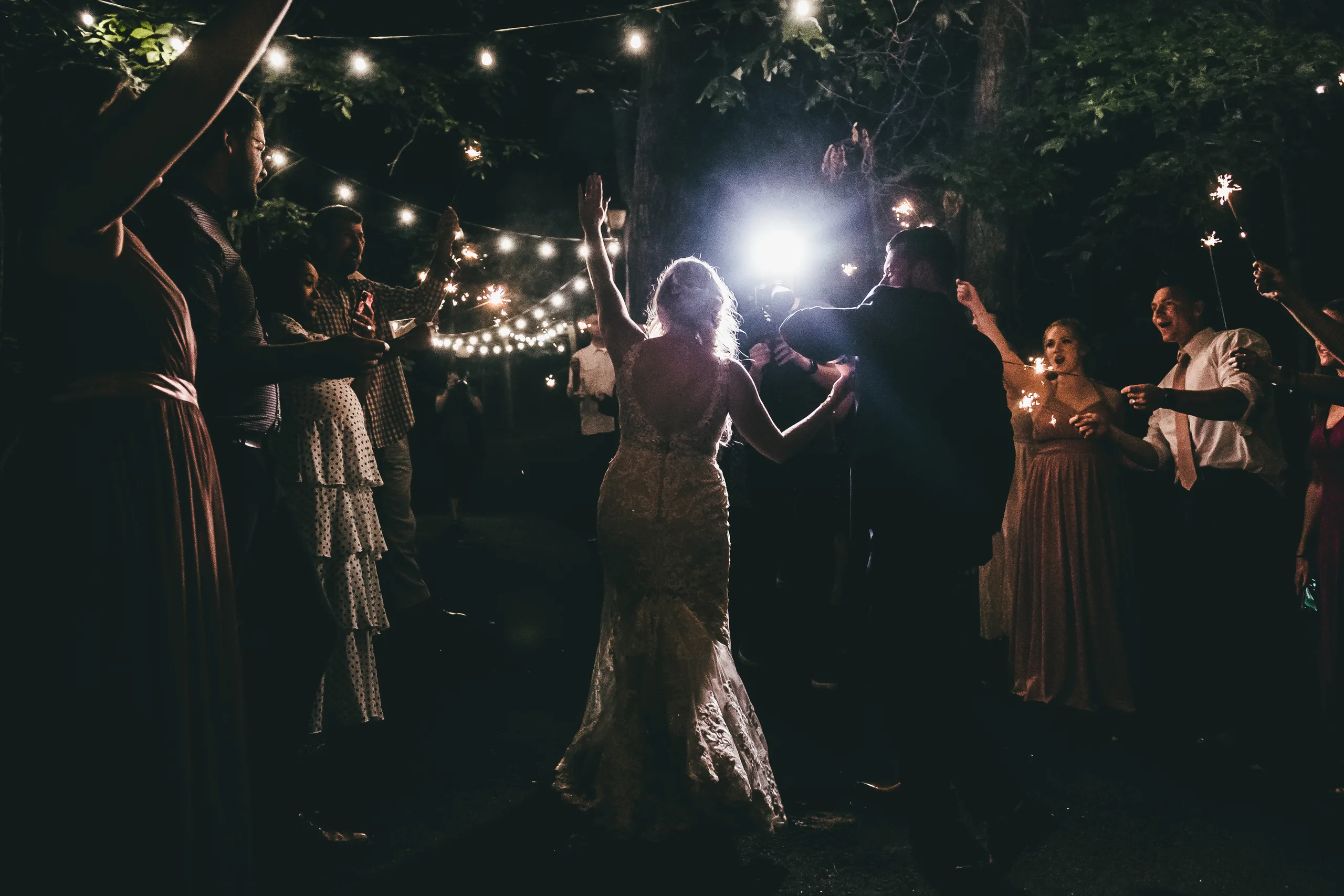 Send-Off: arms up through the sparklers under the string lights, at their wedding at Atlanta Evergreen Lakeside Resort in Stone Mountain, GA