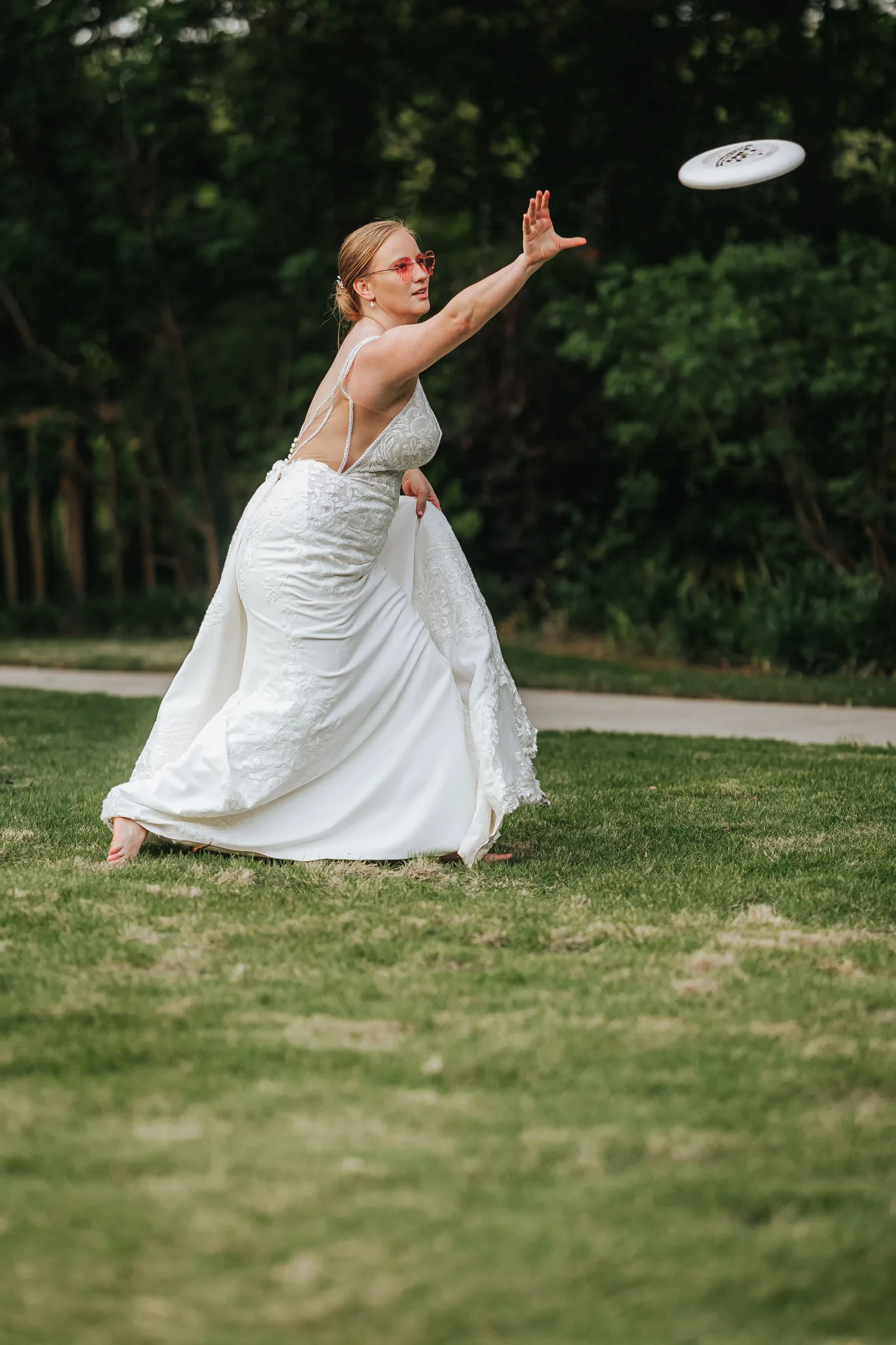 Reception: the bride mid-throw with a frisbee, at their wedding at The Wildflower 301 in Greensboro, GA