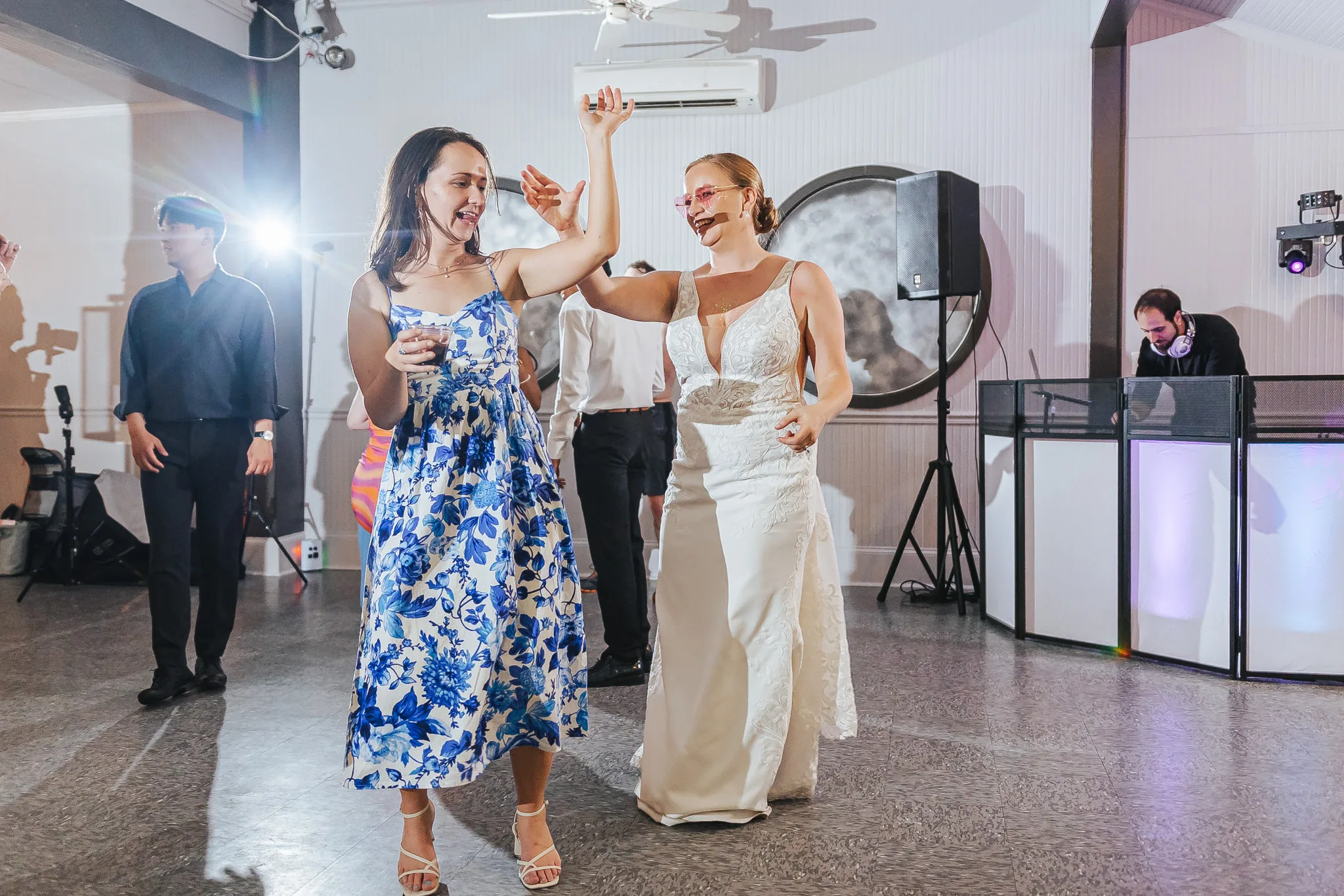 Reception: the bride dancing with a friend, at their wedding at The Wildflower 301 in Greensboro, GA