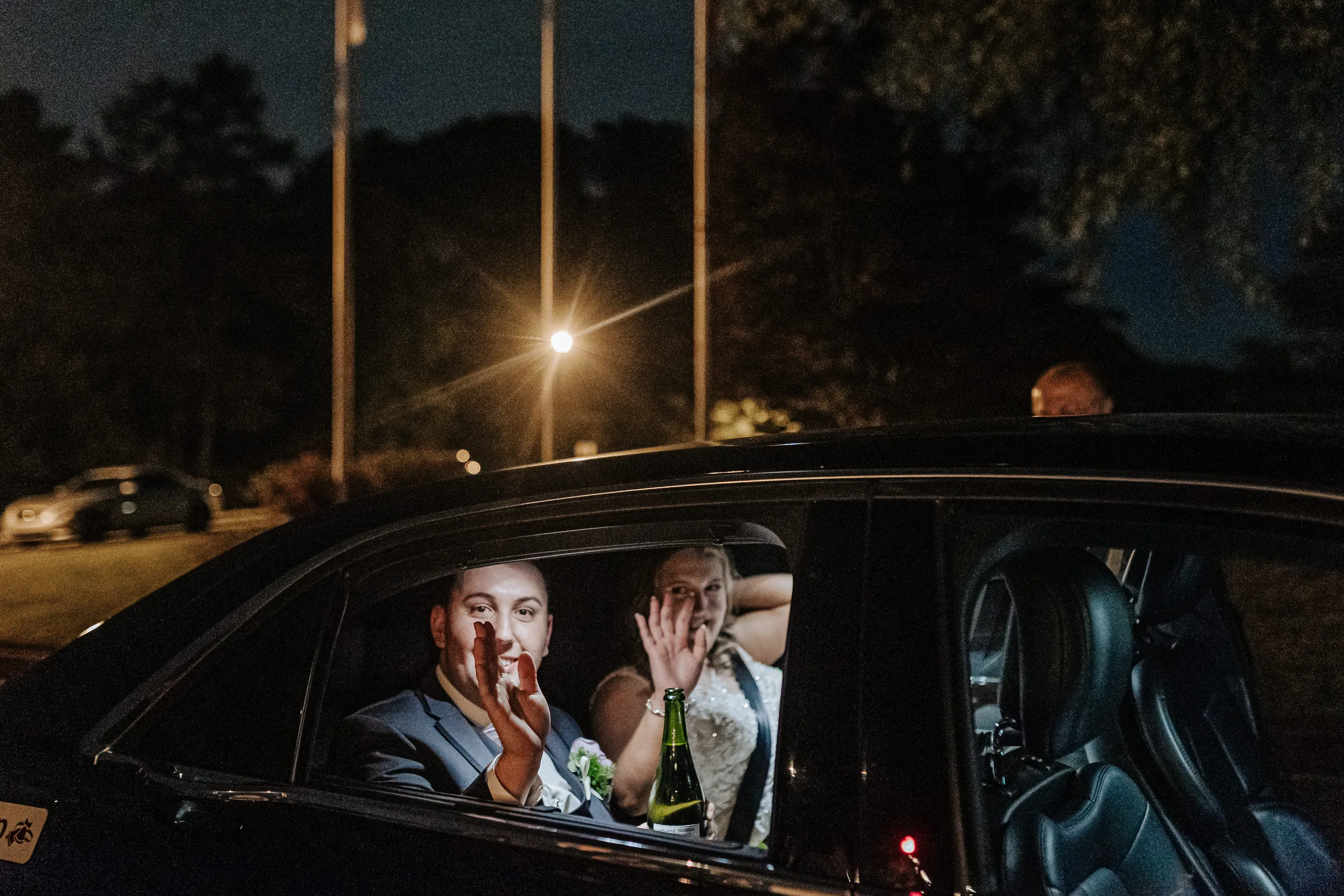 Send-Off: waving from the limo at night at their wedding at the Country Club of Roswell in Roswell, GA