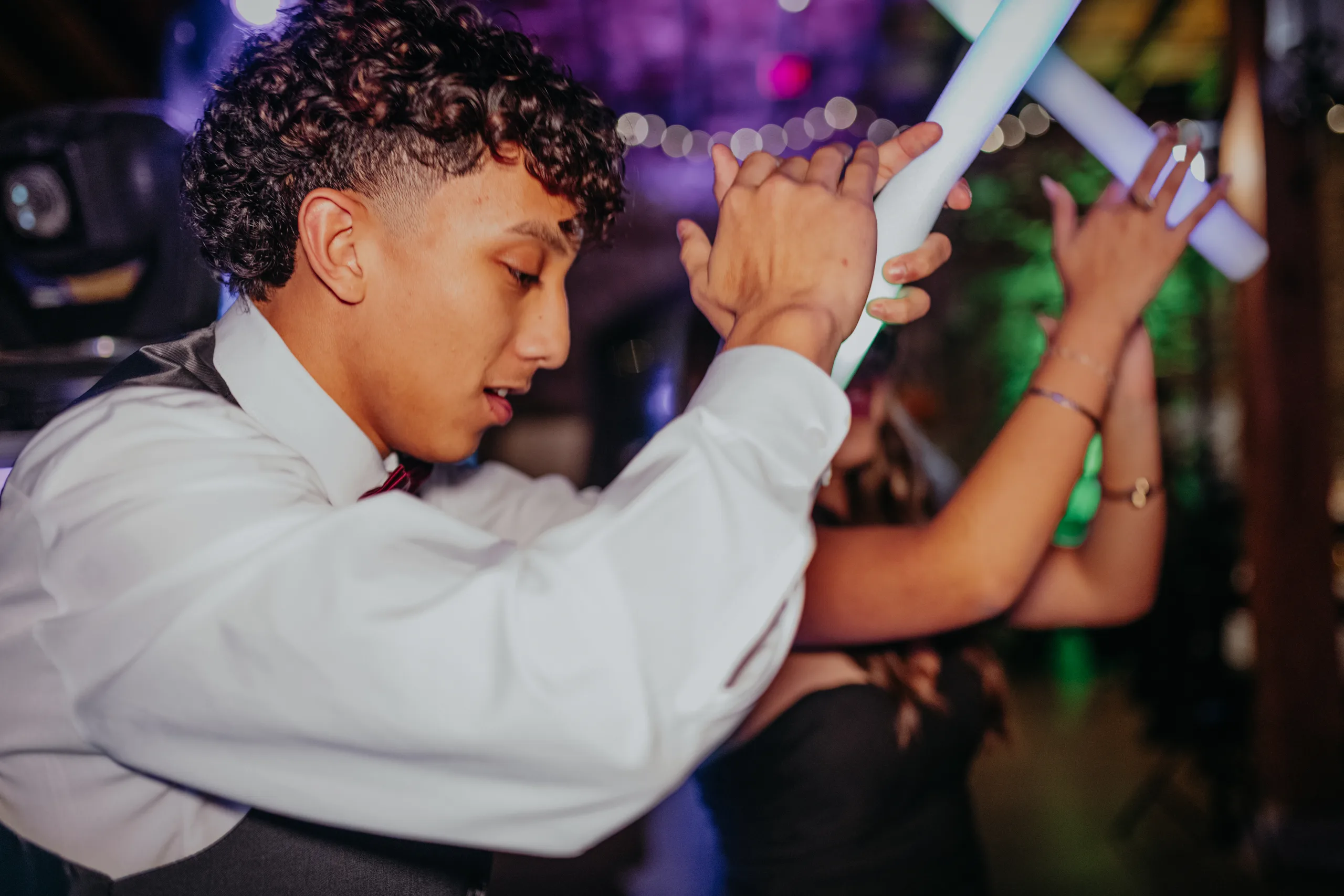 Reception: a guest dancing with a light-up wand, at their wedding at 550 Trackside in Lawrenceville, GA