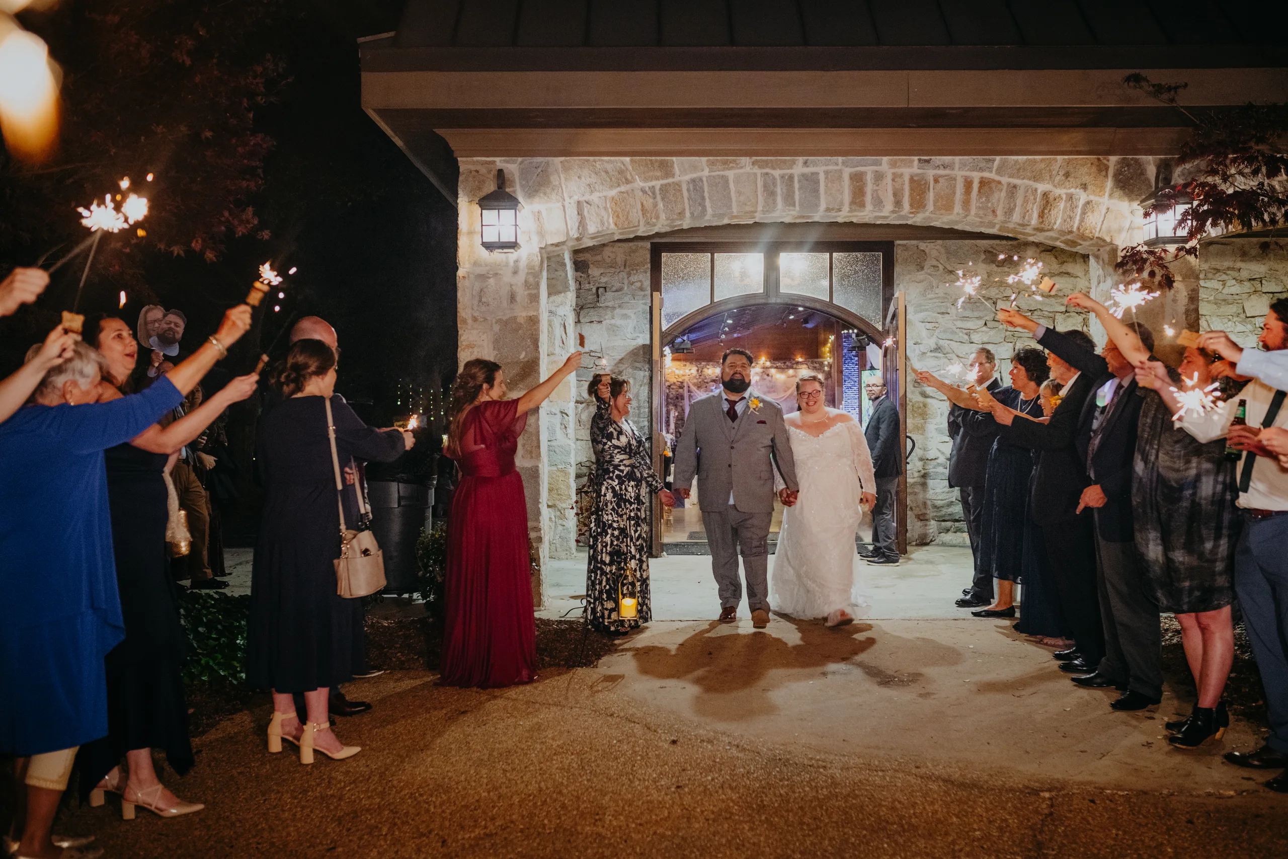 Send-Off: running out through the stone archway between rows of sparklers, at their wedding at 550 Trackside in Lawrenceville, GA