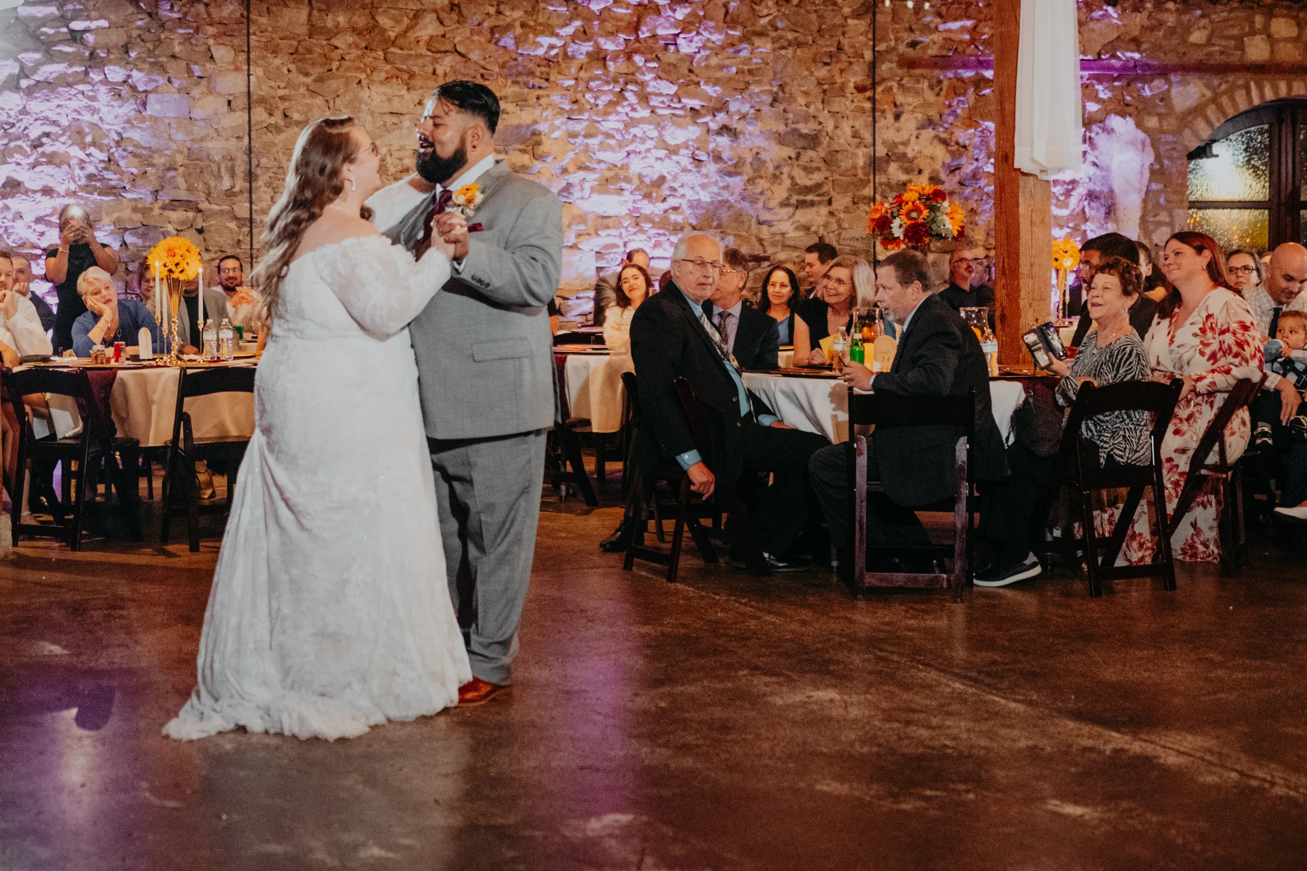 Reception: a dance in front of the stone wall, at their wedding at 550 Trackside in Lawrenceville, GA
