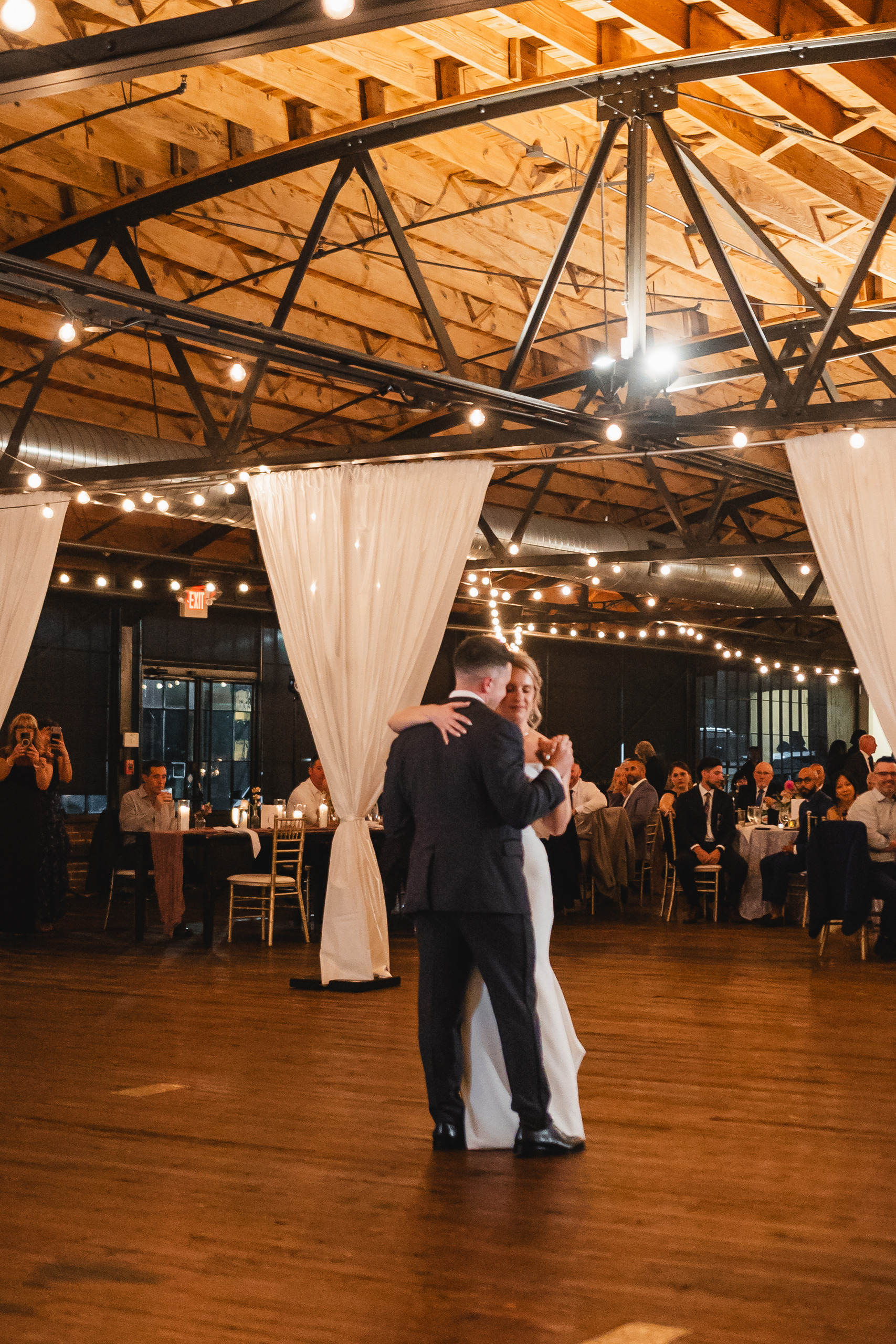 First Dance: the two of them alone on the floor under the lit trusses, at their wedding at Summerour Studio in Atlanta, GA