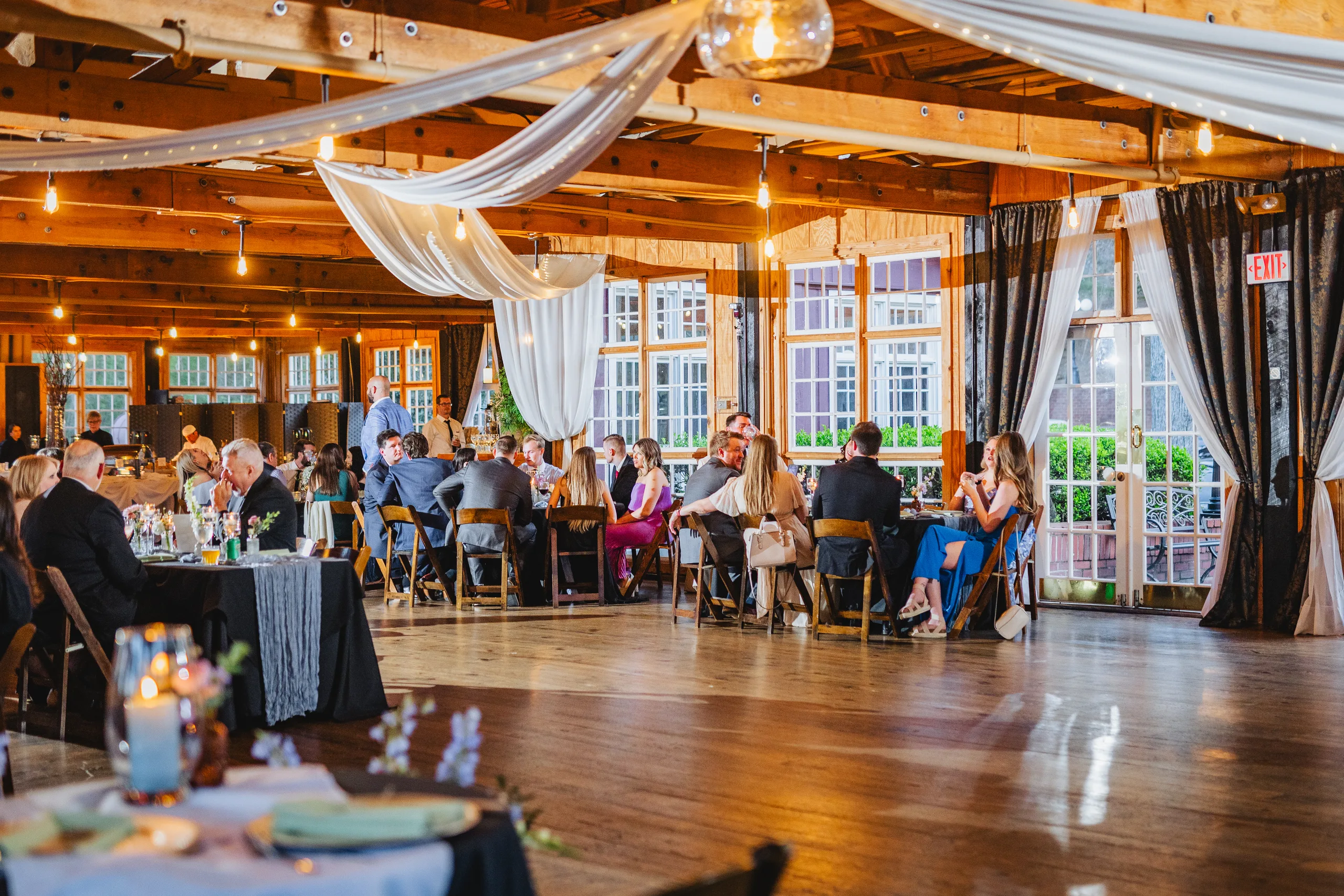 Reception Details: the reception room with draped ceiling and string lights at their wedding at Ivy Hall at Roswell Mill in Roswell, GA