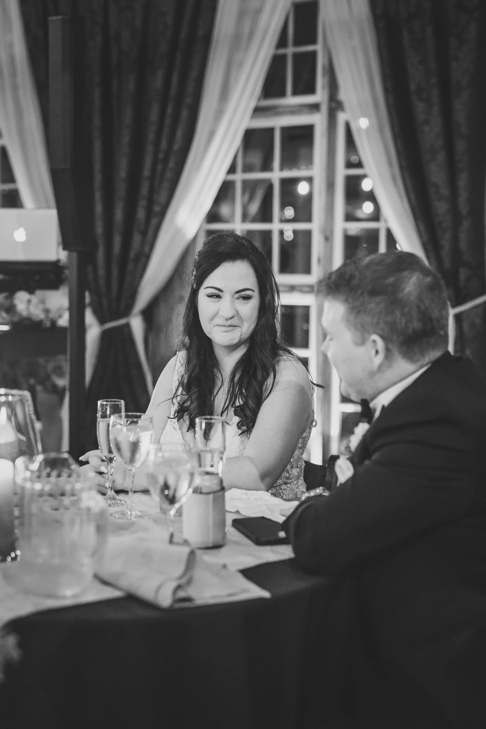 Reception: the two of them at their table, in black and white at their wedding at Ivy Hall at Roswell Mill in Roswell, GA