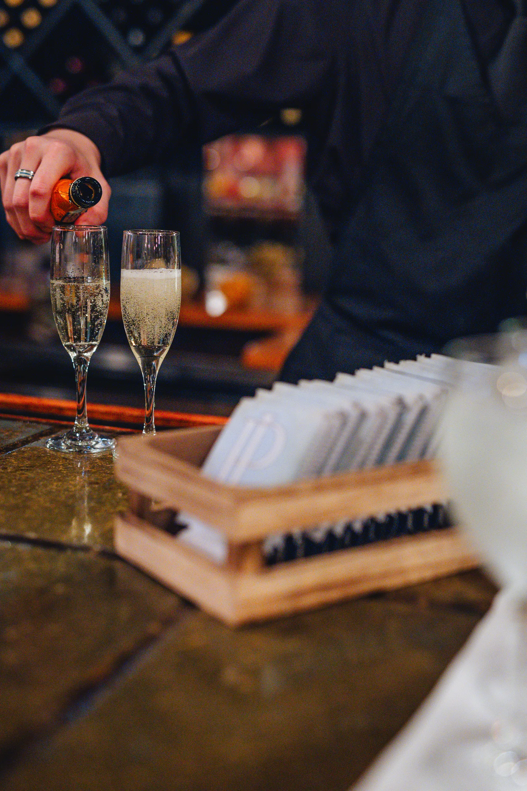 Reception Details: champagne being poured at the bar at a wedding at Ivy Hall at Roswell Mill in Roswell, GA