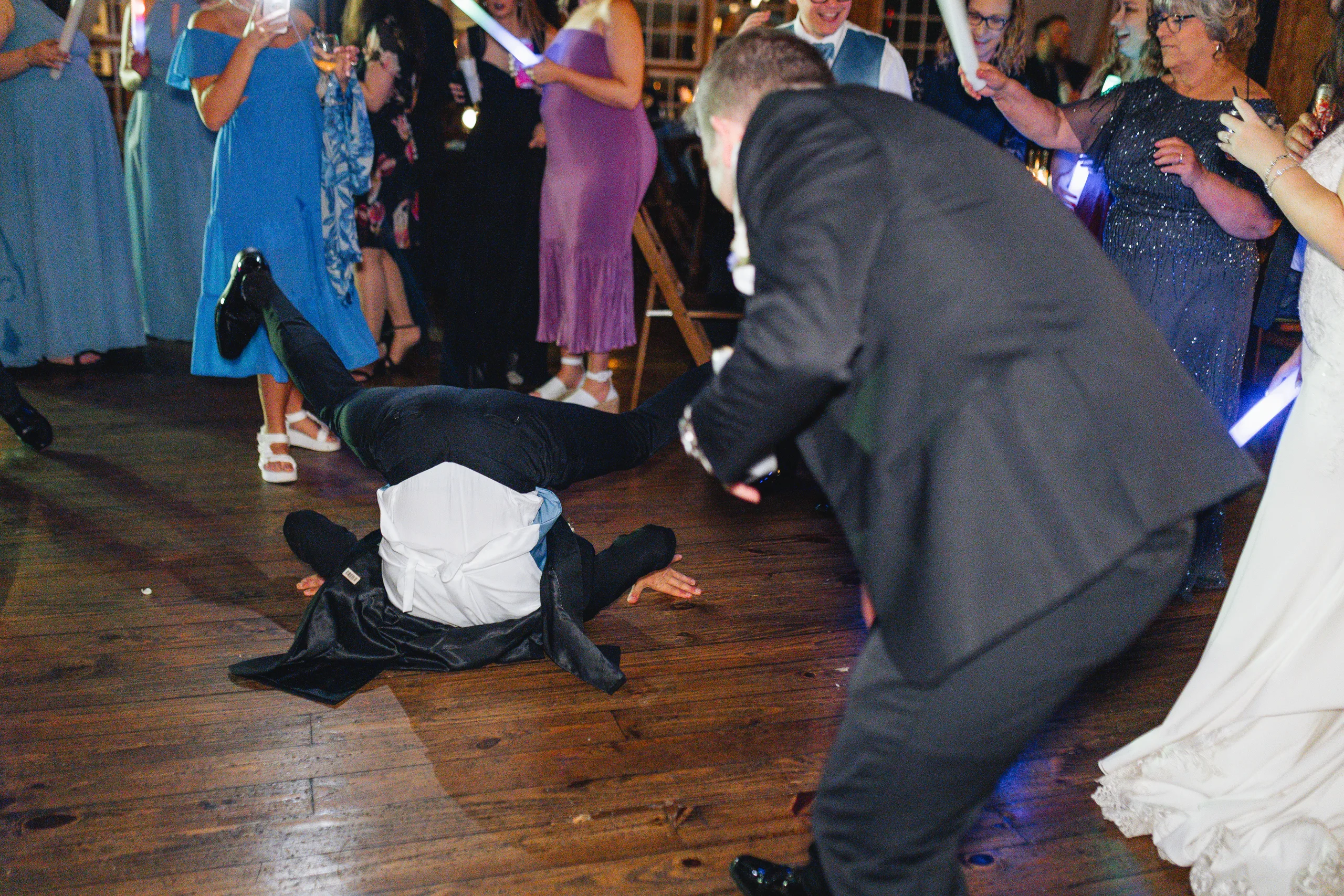 Reception: a guest breakdancing on the dance floor at their wedding at Ivy Hall at Roswell Mill in Roswell, GA