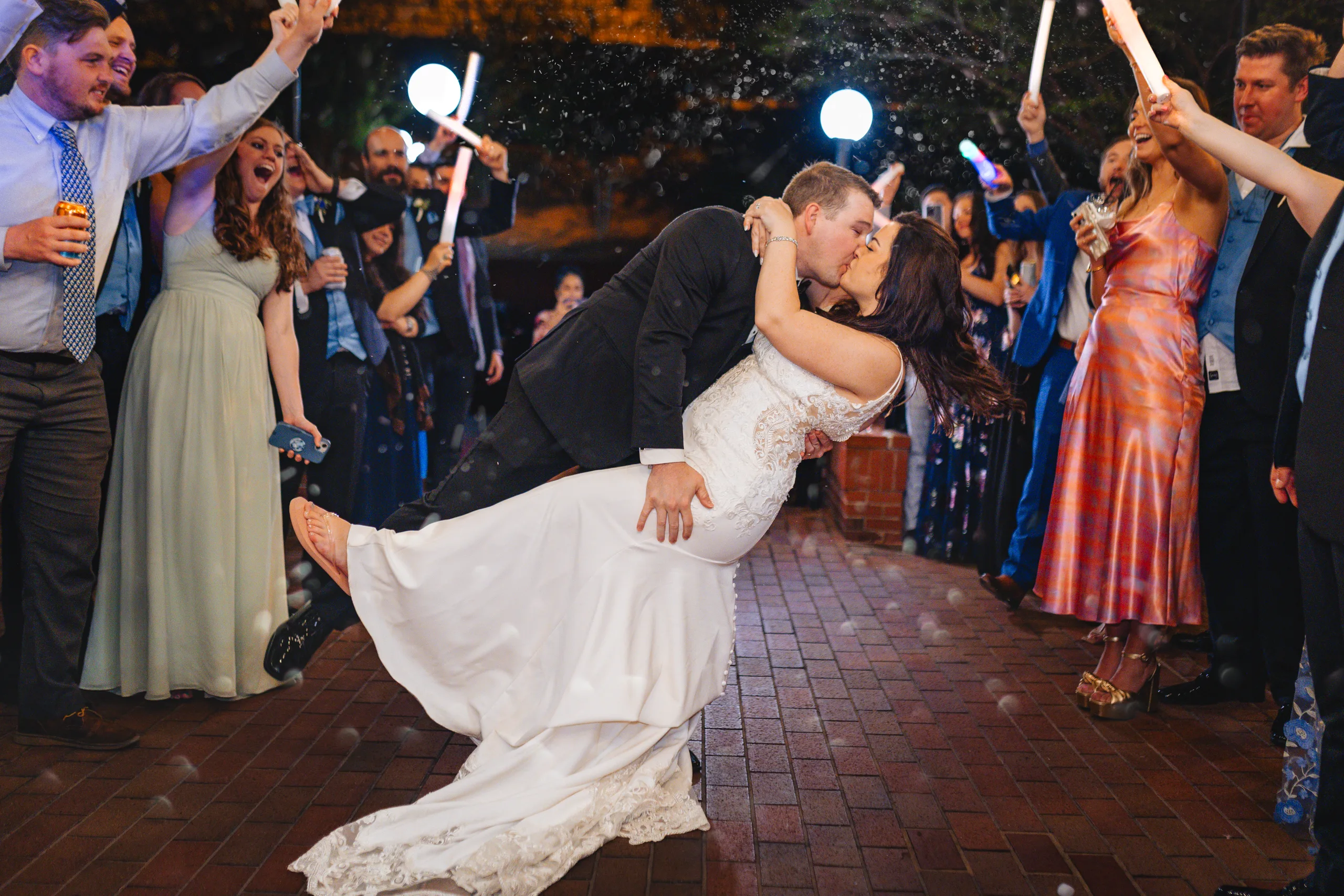 Send-Off: a dip kiss through the champagne and light-up wands at their wedding at Ivy Hall at Roswell Mill in Roswell, GA
