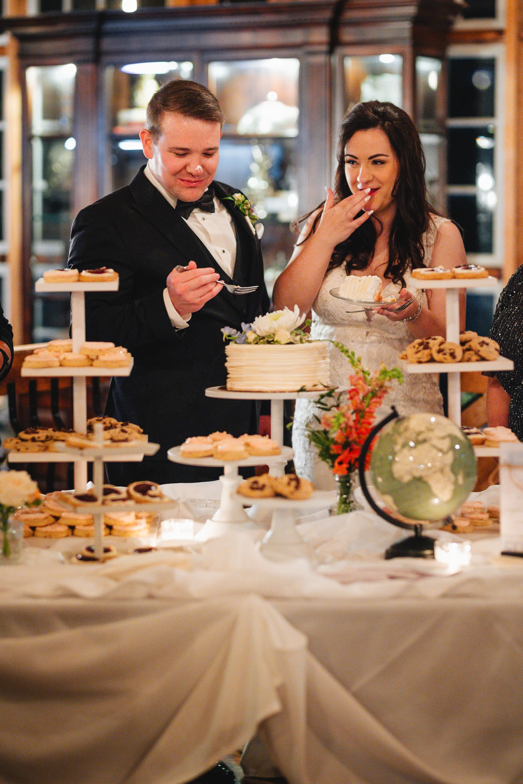 Reception: tasting desserts at the dessert table at their wedding at Ivy Hall at Roswell Mill in Roswell, GA