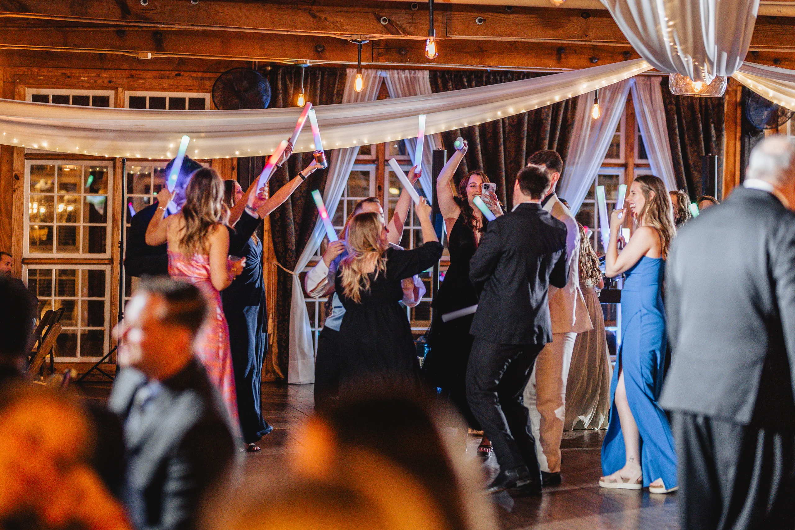 Reception: guests dancing with light-up wands at their wedding at Ivy Hall at Roswell Mill in Roswell, GA