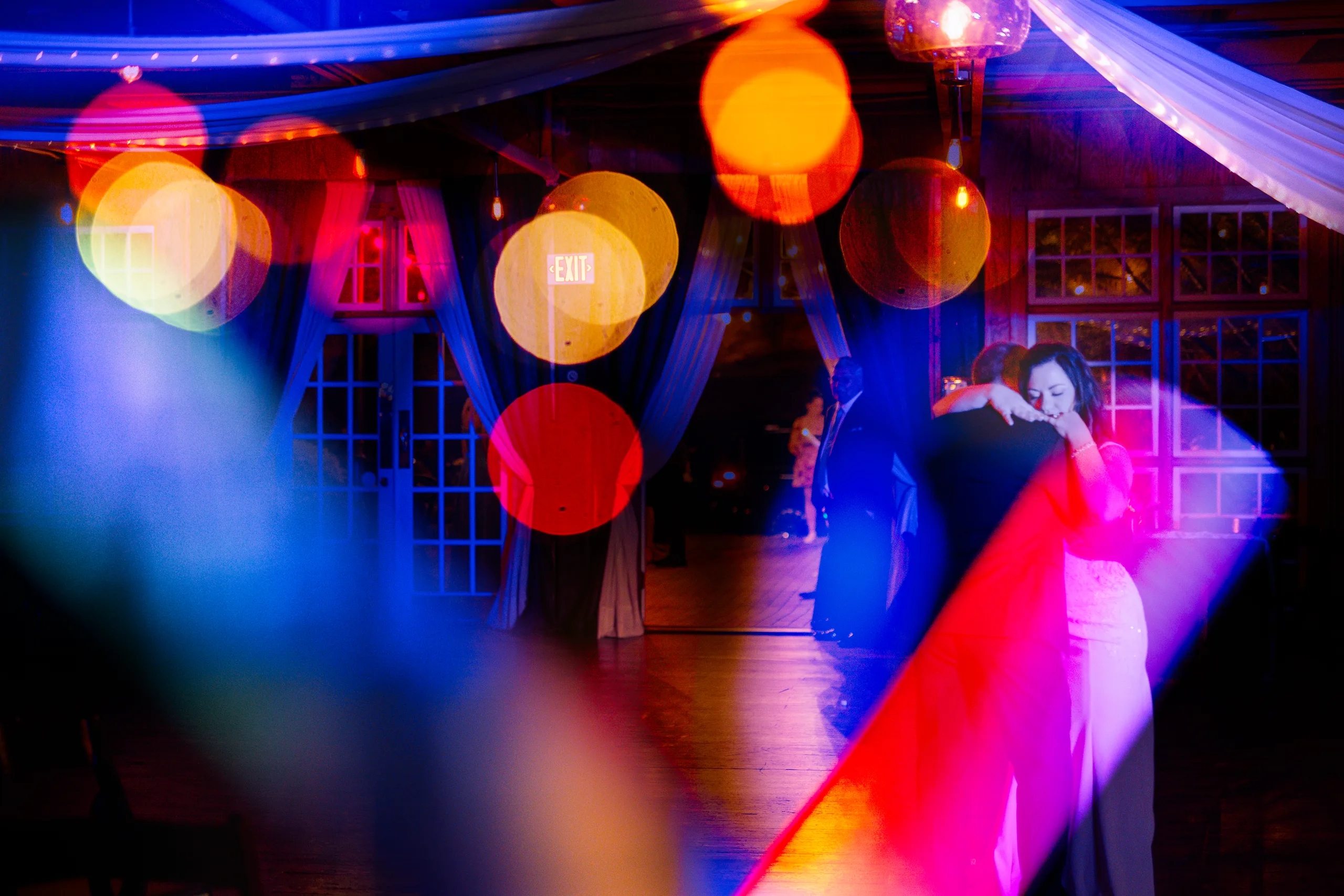 Reception: dancing through colorful lights at their wedding at Ivy Hall at Roswell Mill in Roswell, GA
