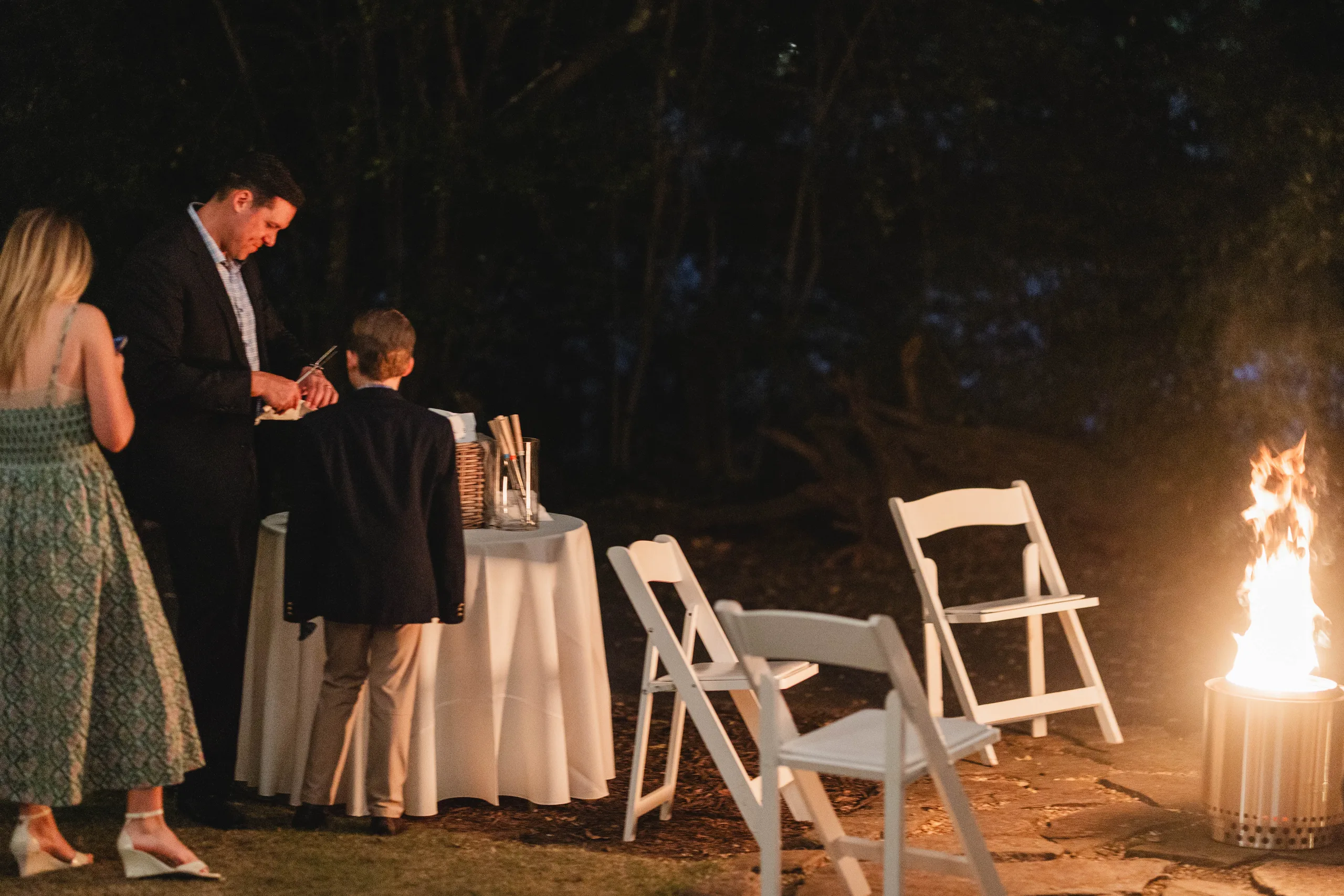 Reception: guests by the fire pit outside, at their wedding at Naylor Hall in Roswell, GA