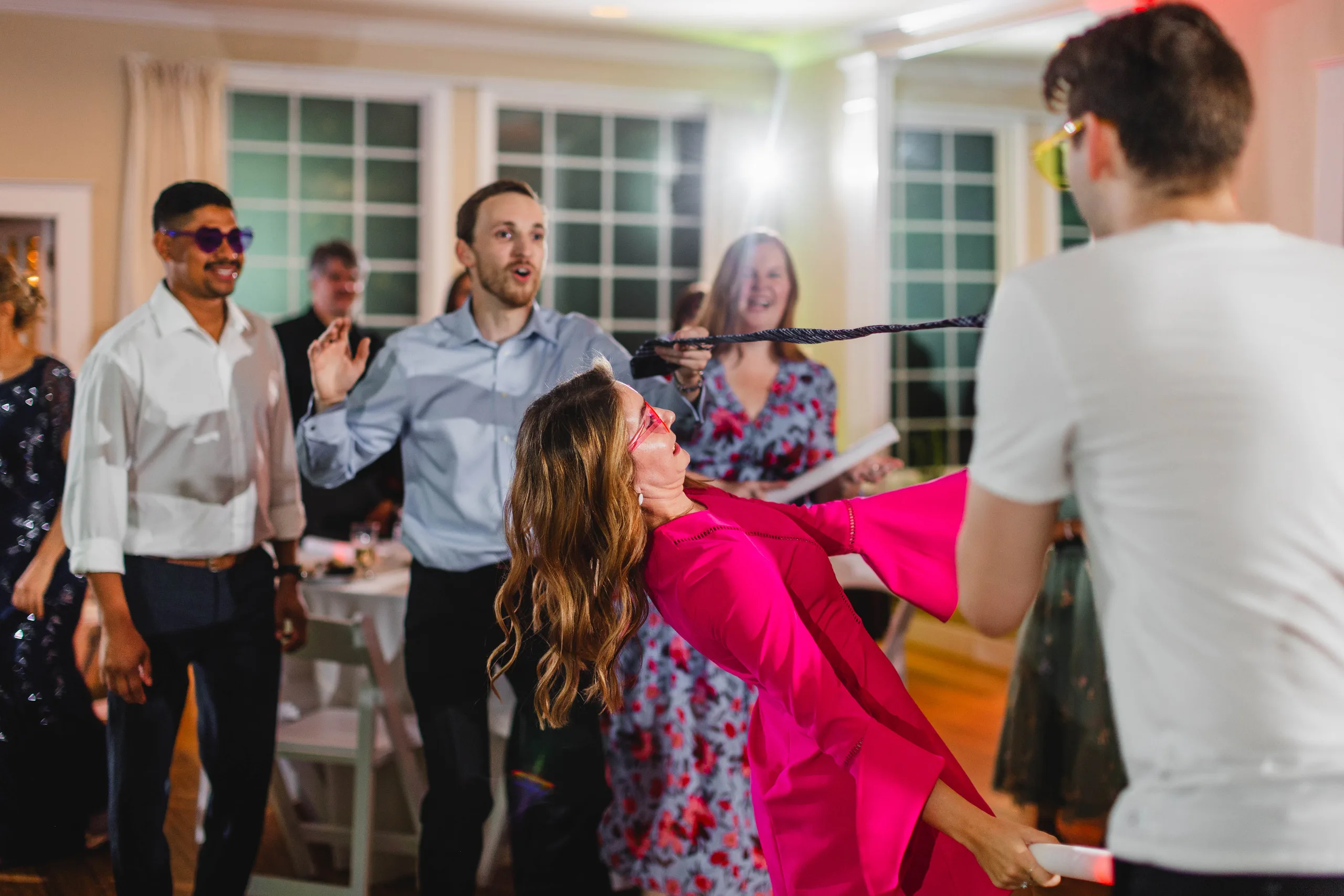 Reception: a guest bending under the limbo stick, at their wedding at Naylor Hall in Roswell, GA