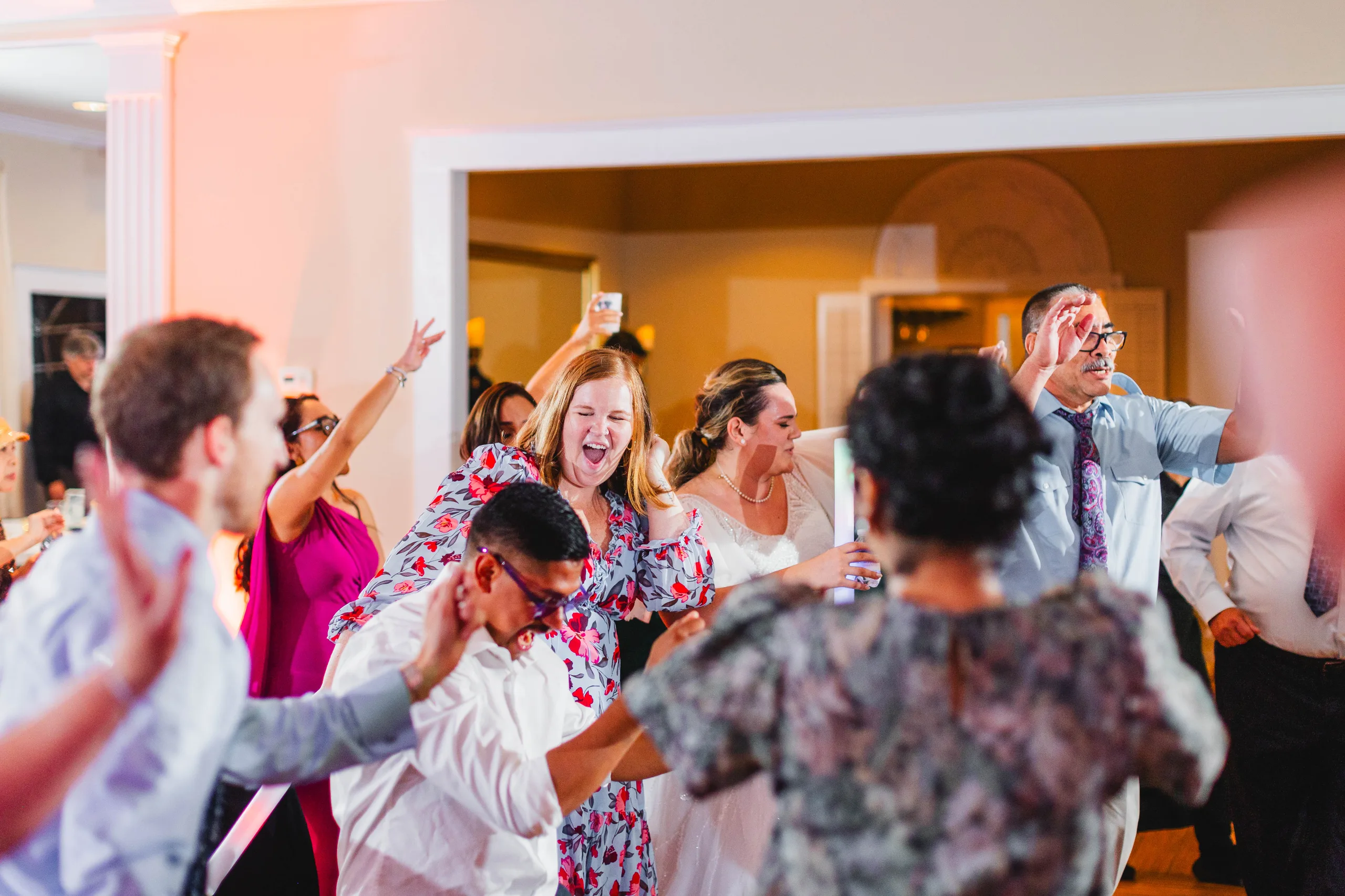 Reception: the dance floor packed with guests, at their wedding at Naylor Hall in Roswell, GA