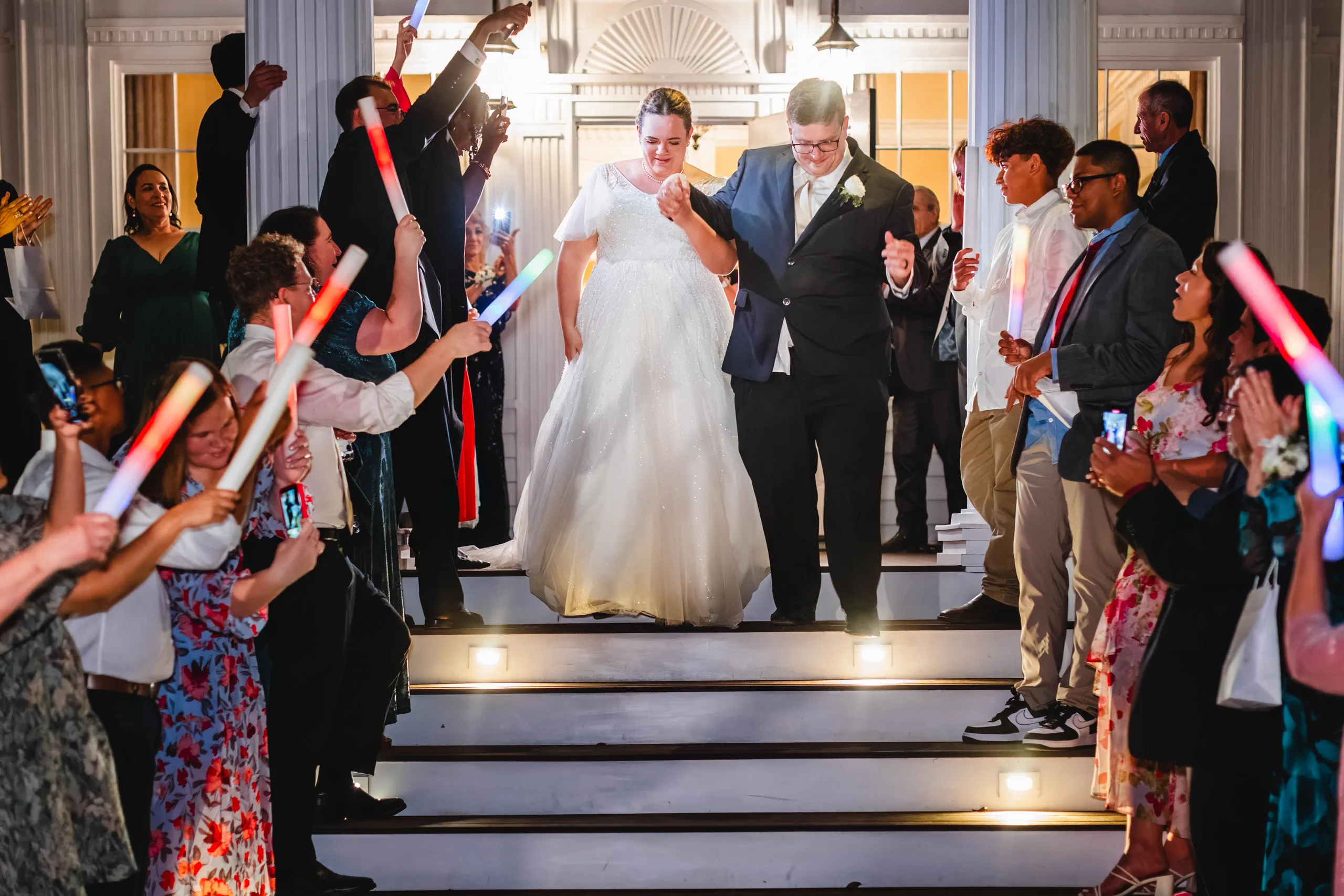 Send-Off: coming down the front steps through a tunnel of light-up wands, at their wedding at Naylor Hall in Roswell, GA