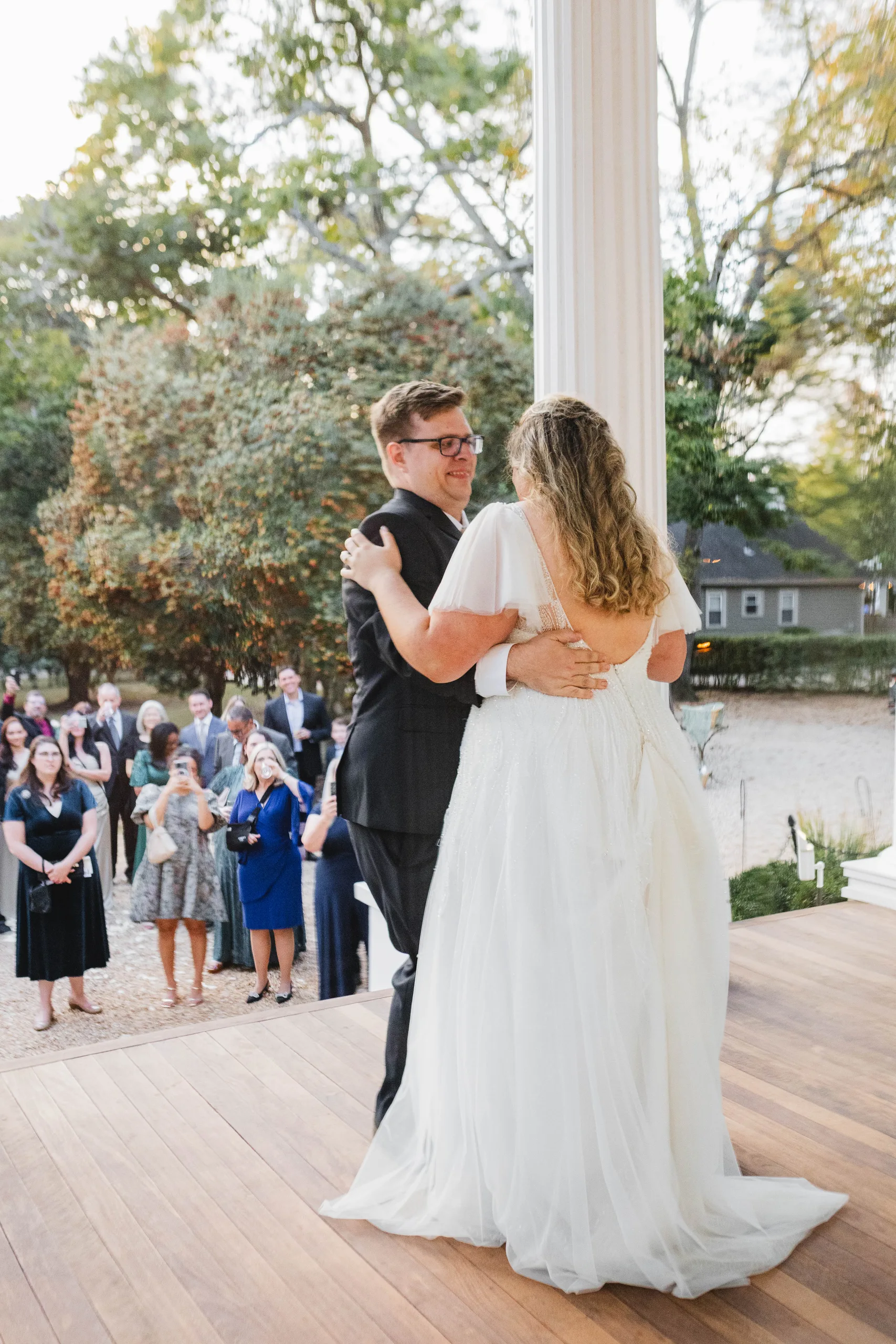 First Dance: their first dance on the front porch as guests watch from the lawn, at their wedding at Naylor Hall in Roswell, GA