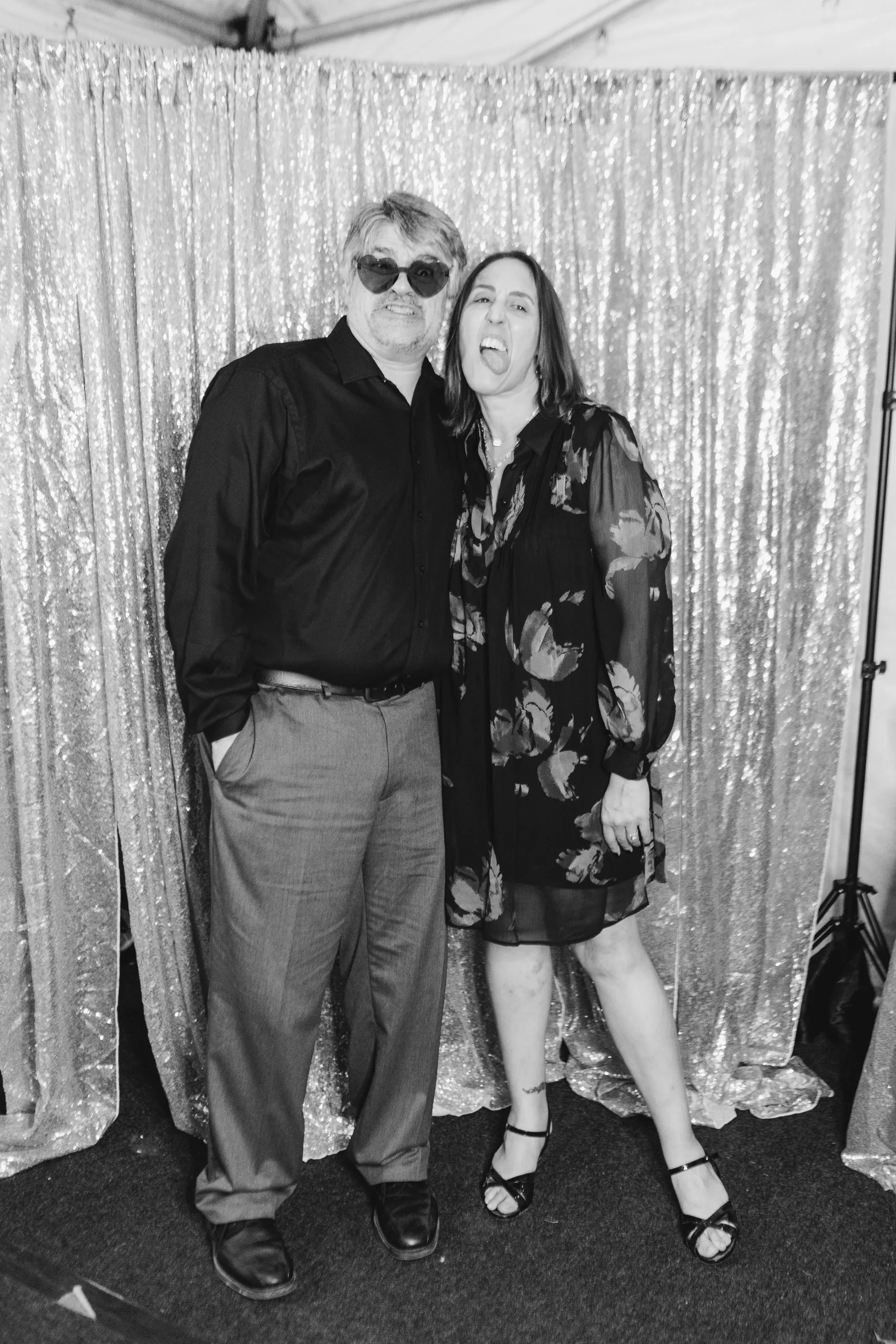 Reception: two guests hamming it up in the photo booth, in black and white, at their wedding at Naylor Hall in Roswell, GA