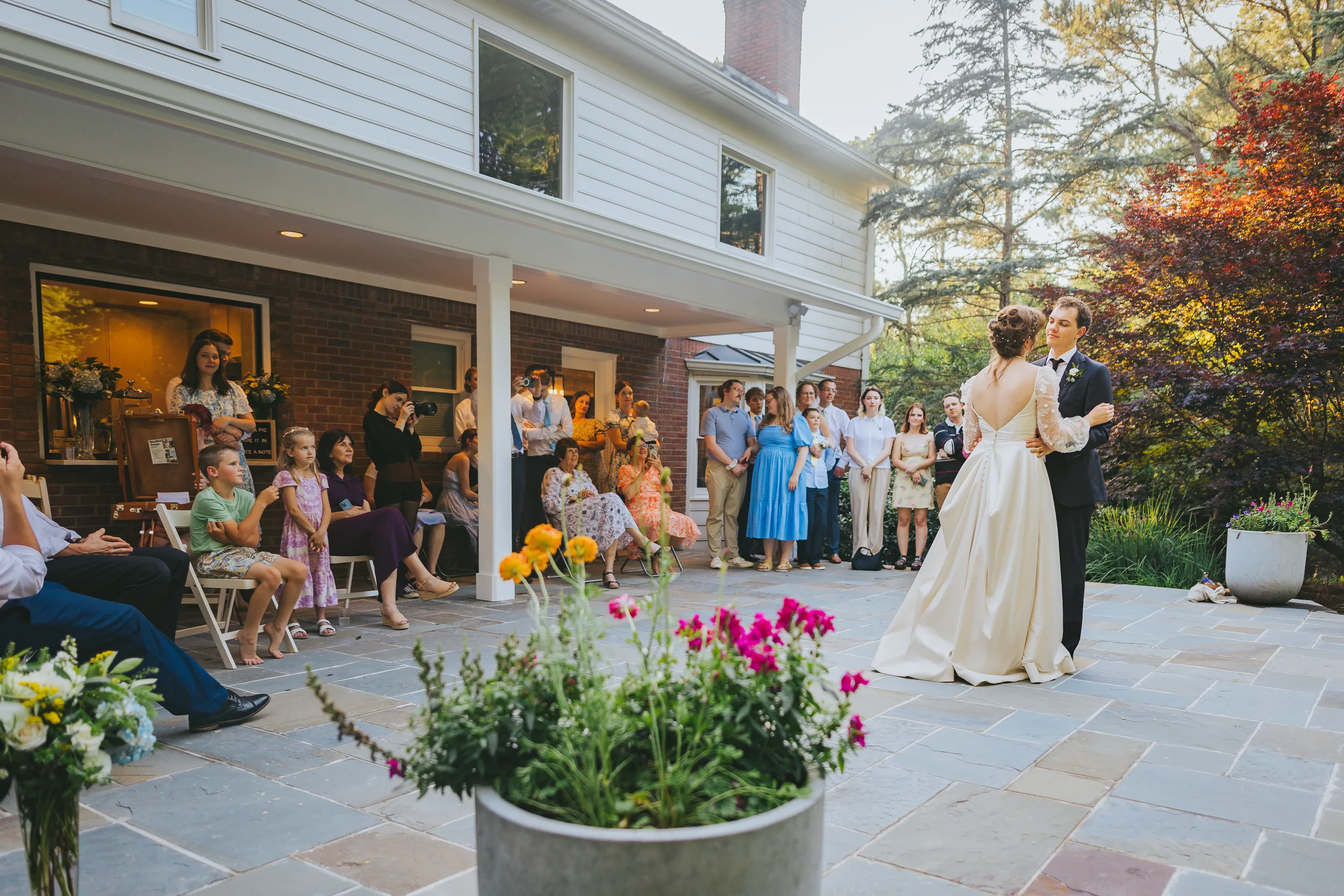 First Dance: their first dance on the patio as family watches, at their wedding reception at a family home