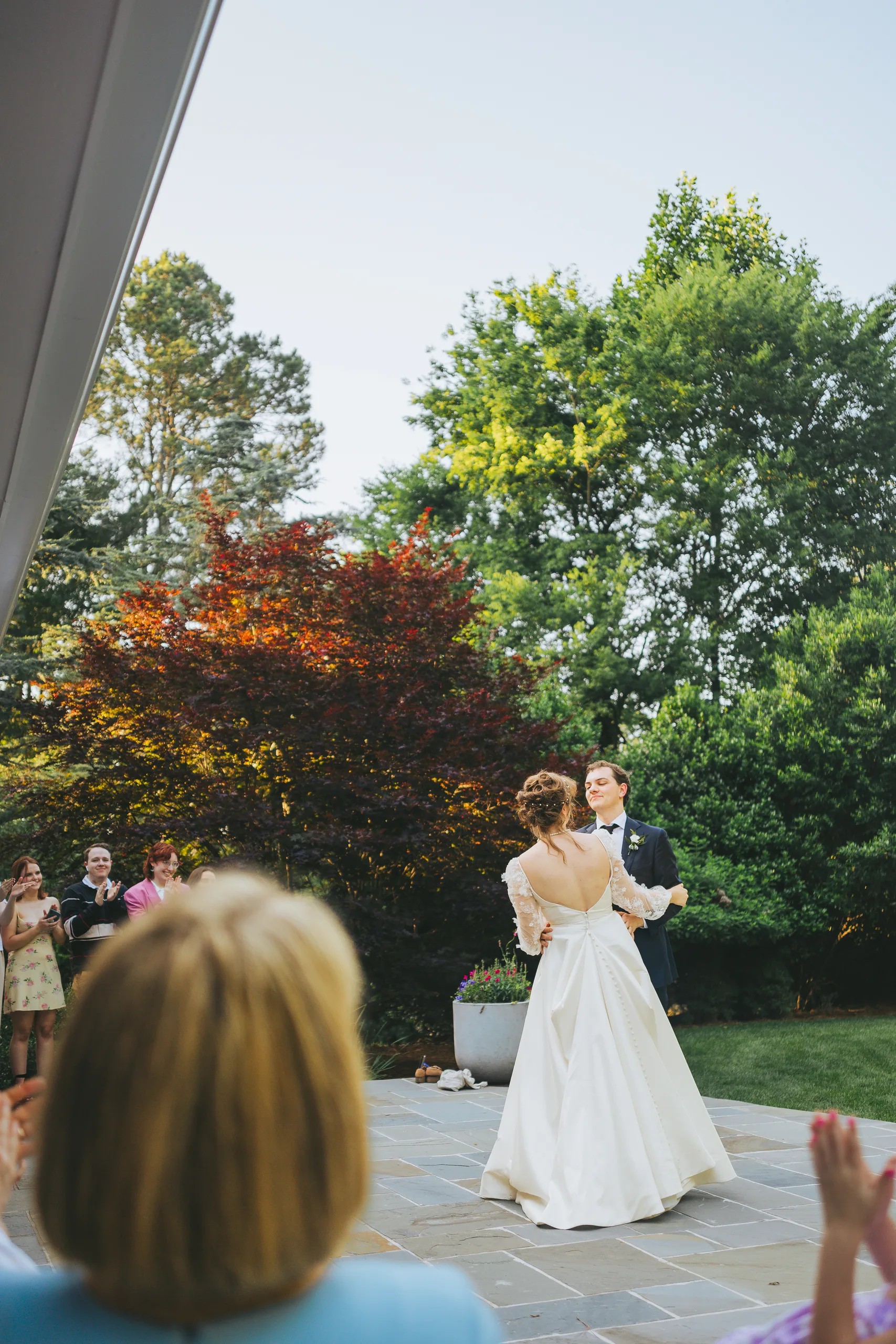 First Dance: dancing on the patio under the trees, at their wedding reception at a family home