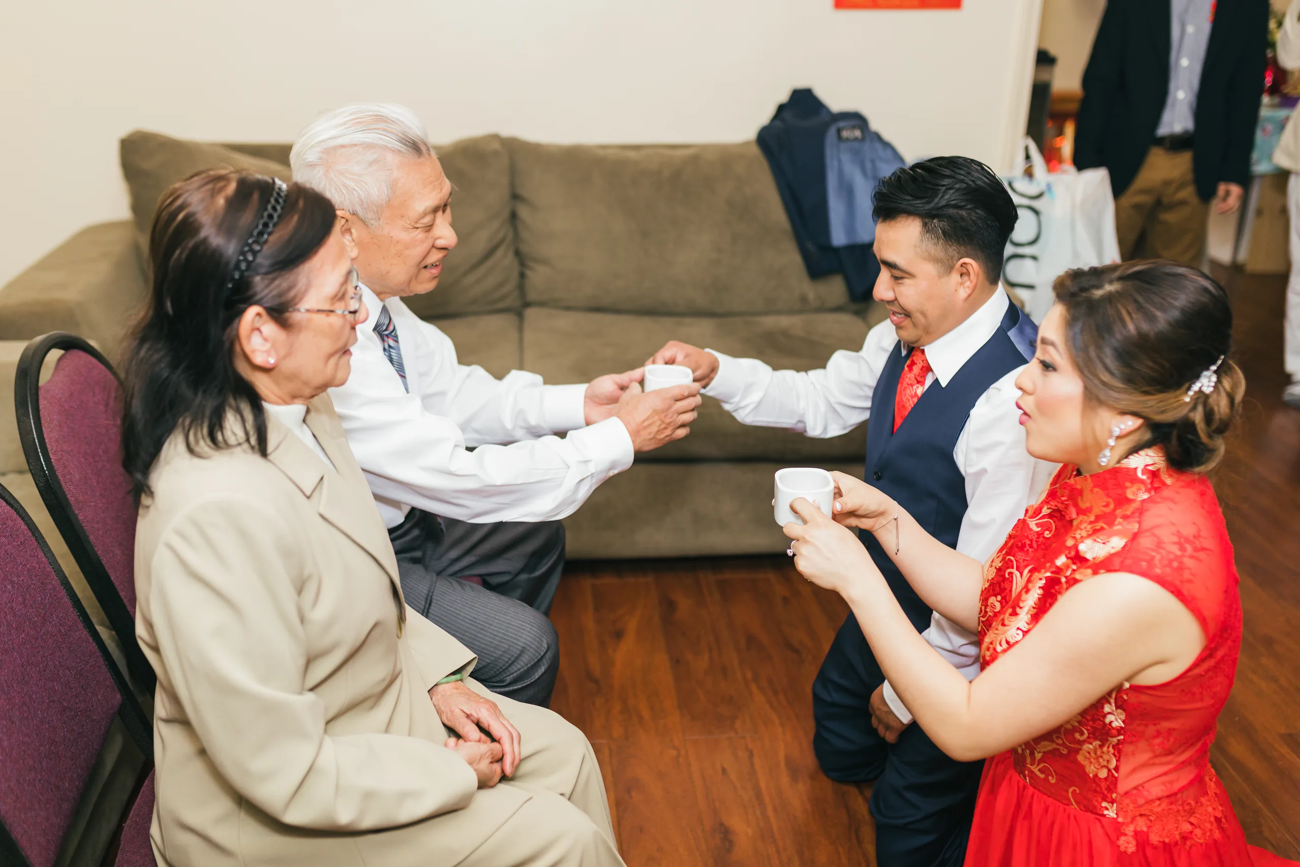 Tea Ceremony: the couple kneeling to serve tea to their elders before their wedding at the Payne-Corley House in Duluth, GA