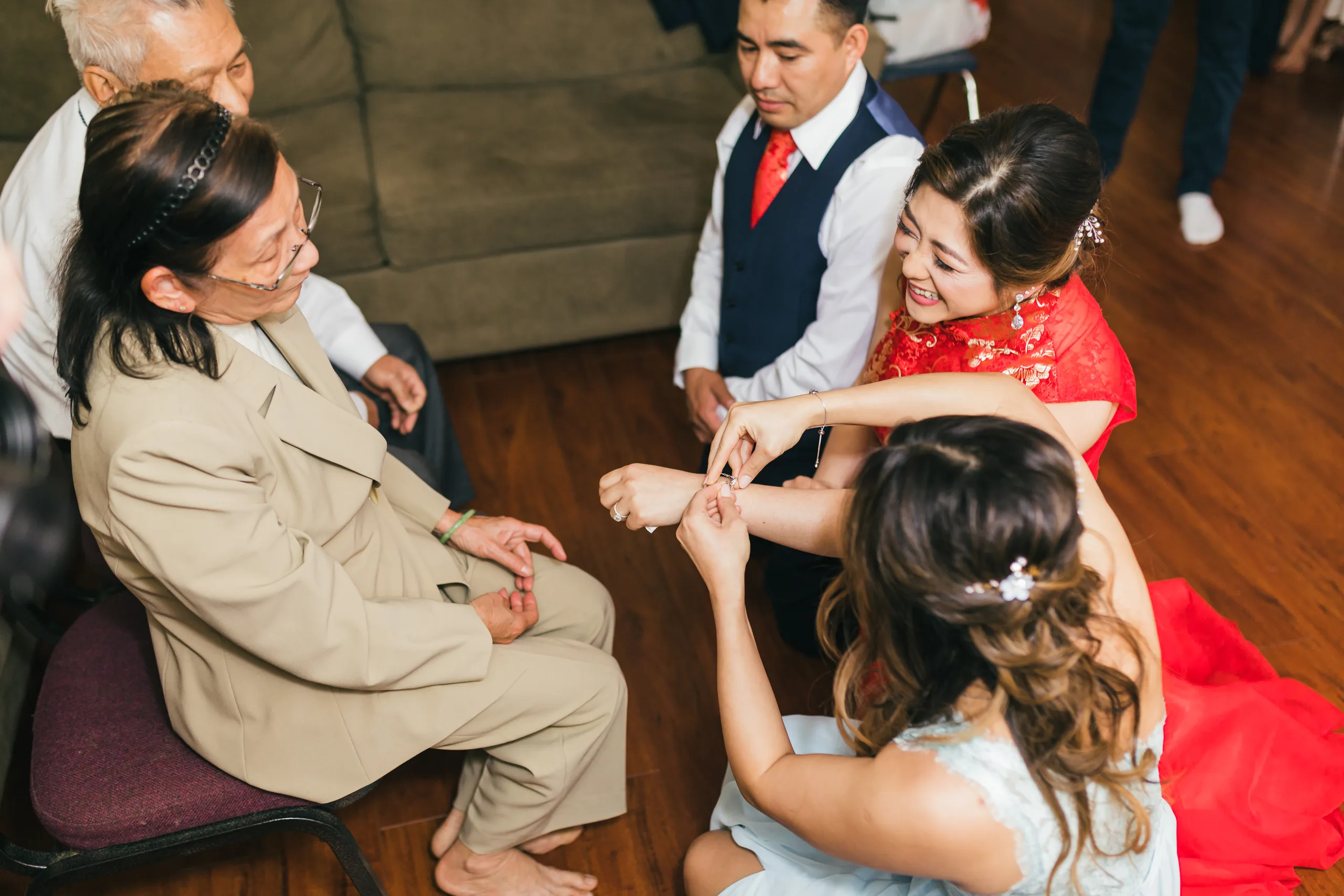 Tea Ceremony: the bride in red receiving a gift from her family before their wedding at the Payne-Corley House in Duluth, GA