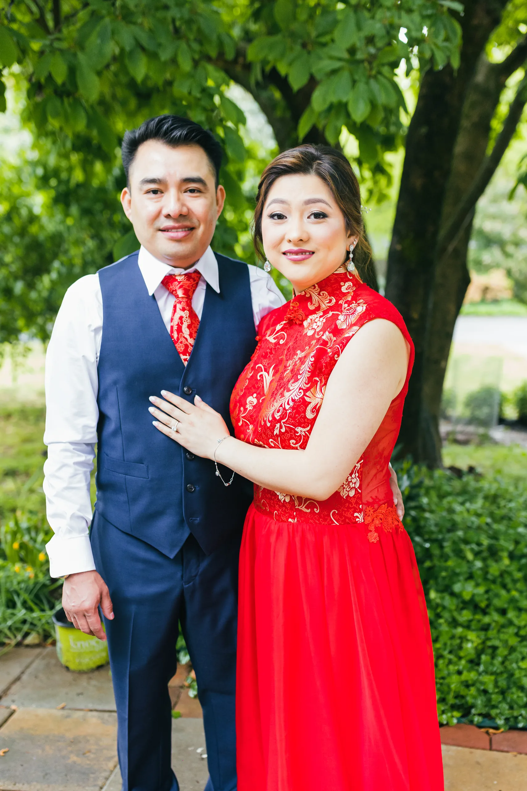 Tea Ceremony: the couple in red standing together in the garden before their wedding at the Payne-Corley House in Duluth, GA